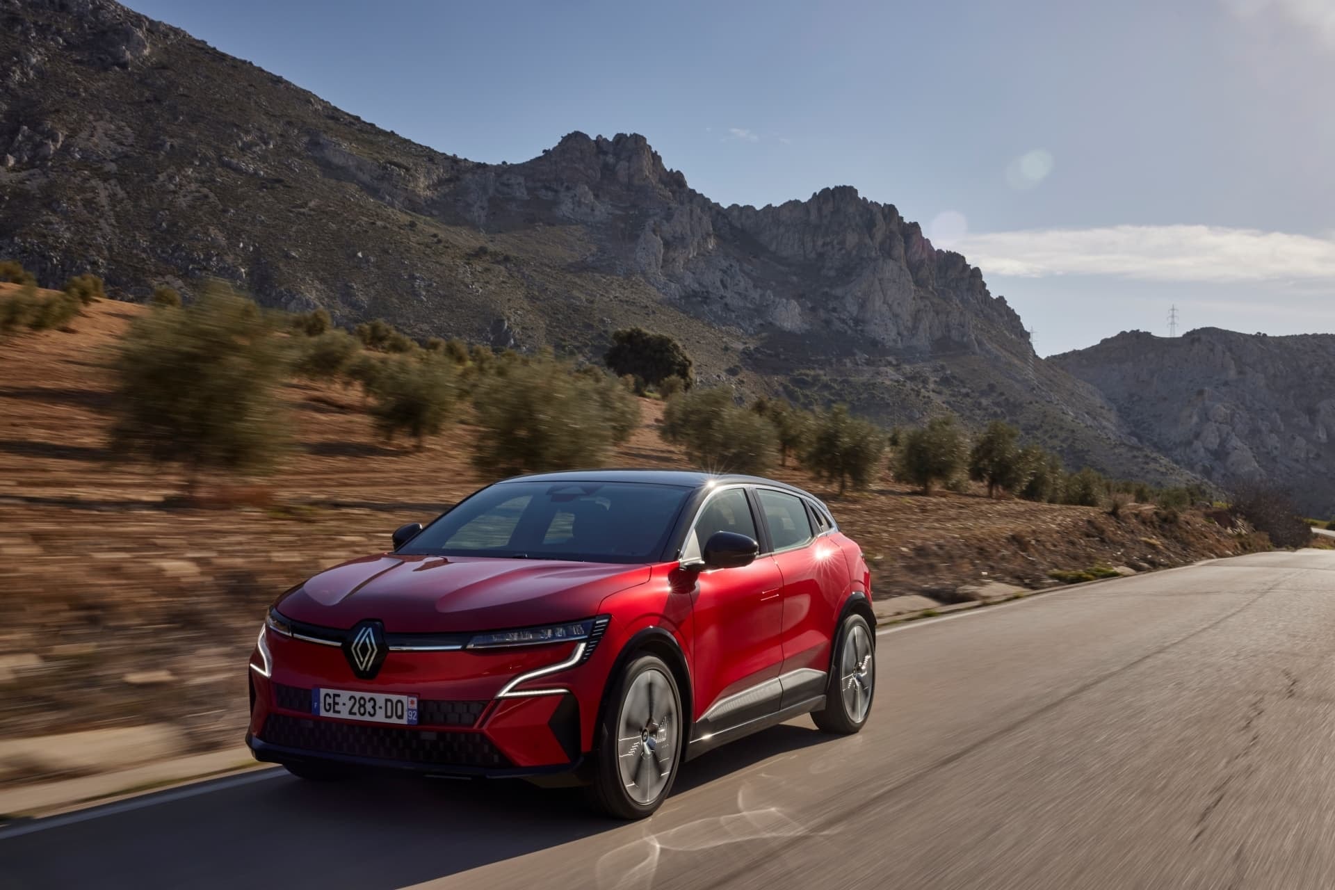 Renault Mégane E-Tech vista lateral- trasera en carretera montañosa.