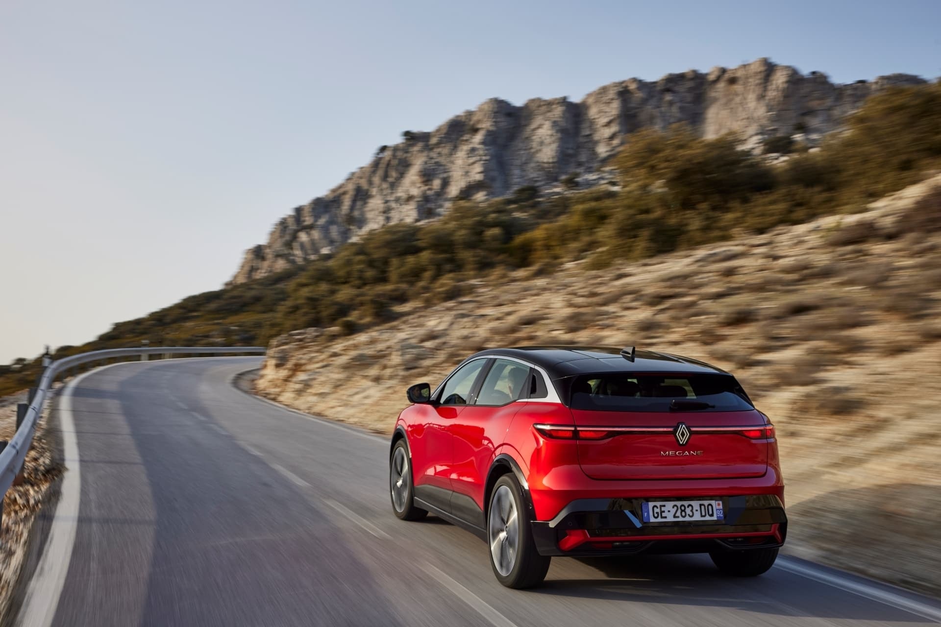 Renault Mégane E-Tech eléctrico con una vista lateral y trasera en ruta paisajística.