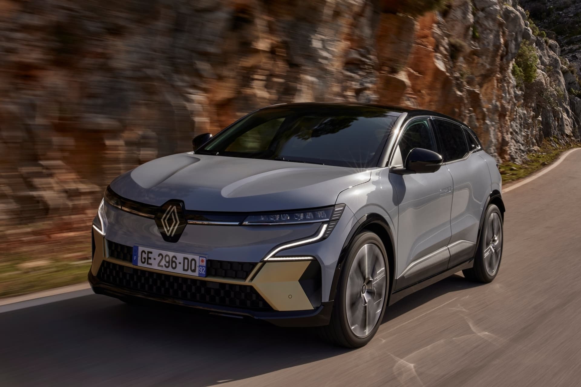 Conducción del Mégane E-Tech eléctrico con paisaje montañoso de fondo.
