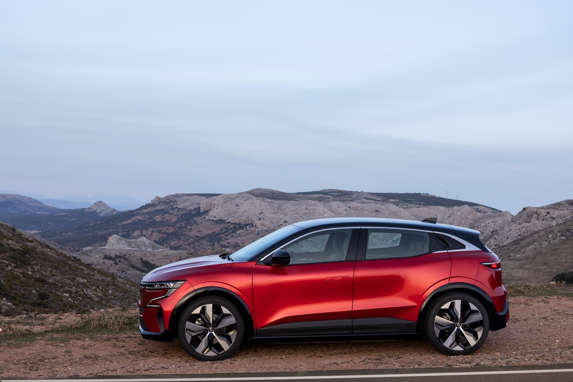 Vista lateral del Renault Mégane E-Tech eléctrico en un entorno natural.