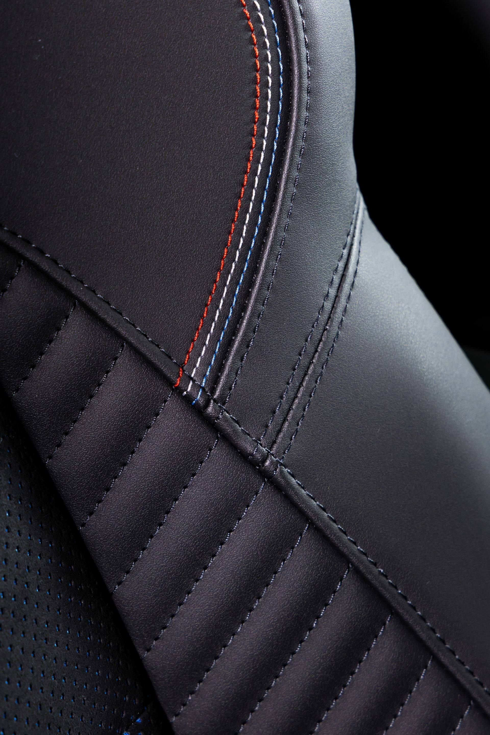 Enfoque en el asiento del conductor, mostrando diseño ergonómico y controles de ajuste.