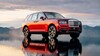 Vista lateral del Rolls Royce Cullinan en rojo bajo cielo nublado. Vista lateral del Rolls Royce Cullinan en rojo bajo cielo nublado.