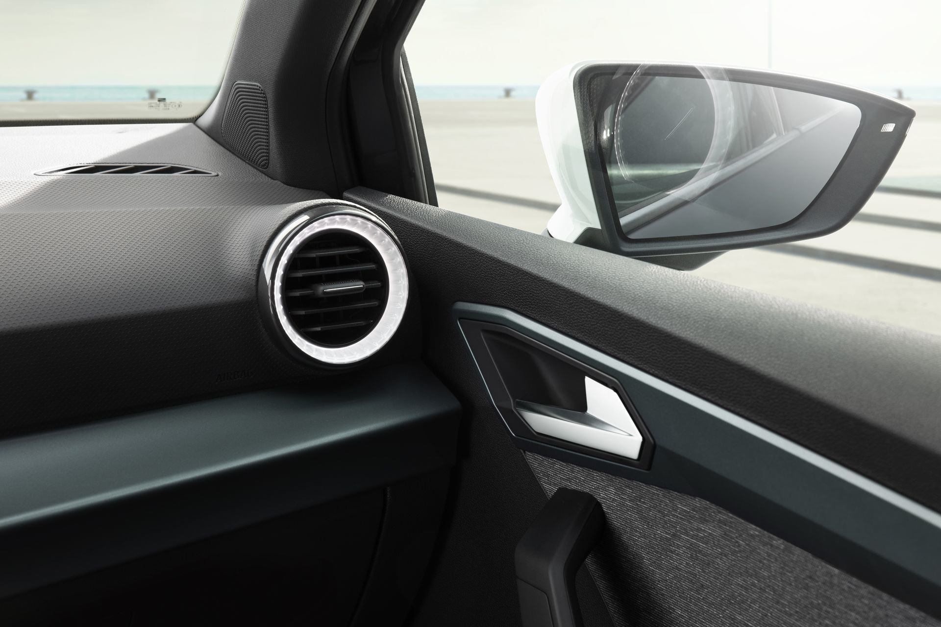 Recorte que muestra el espejo retrovisor y aireadores con diseño minimalista.