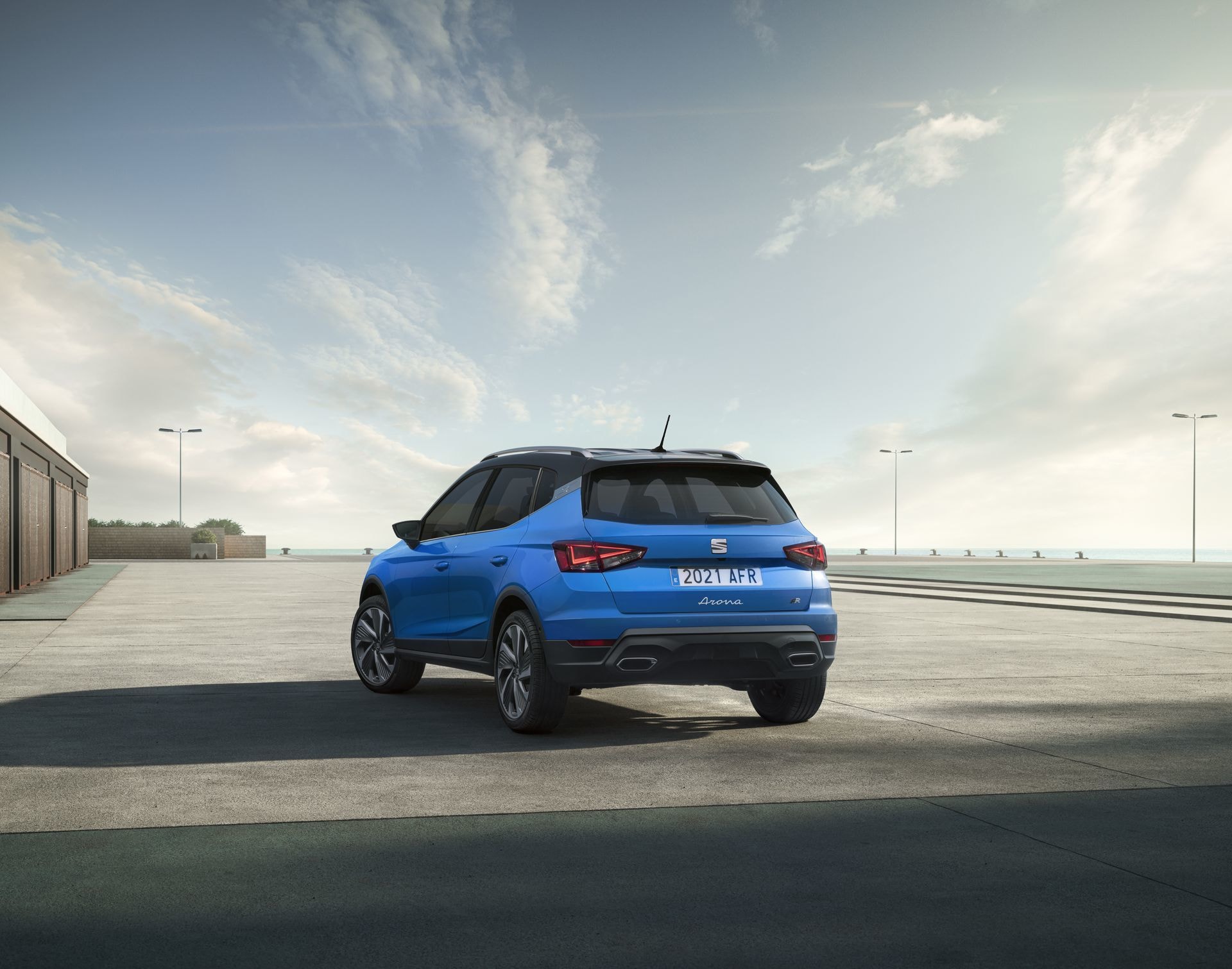 Vista trasera y lateral del SEAT Arona azul, evidenciando sus ópticas y diseño posterior.