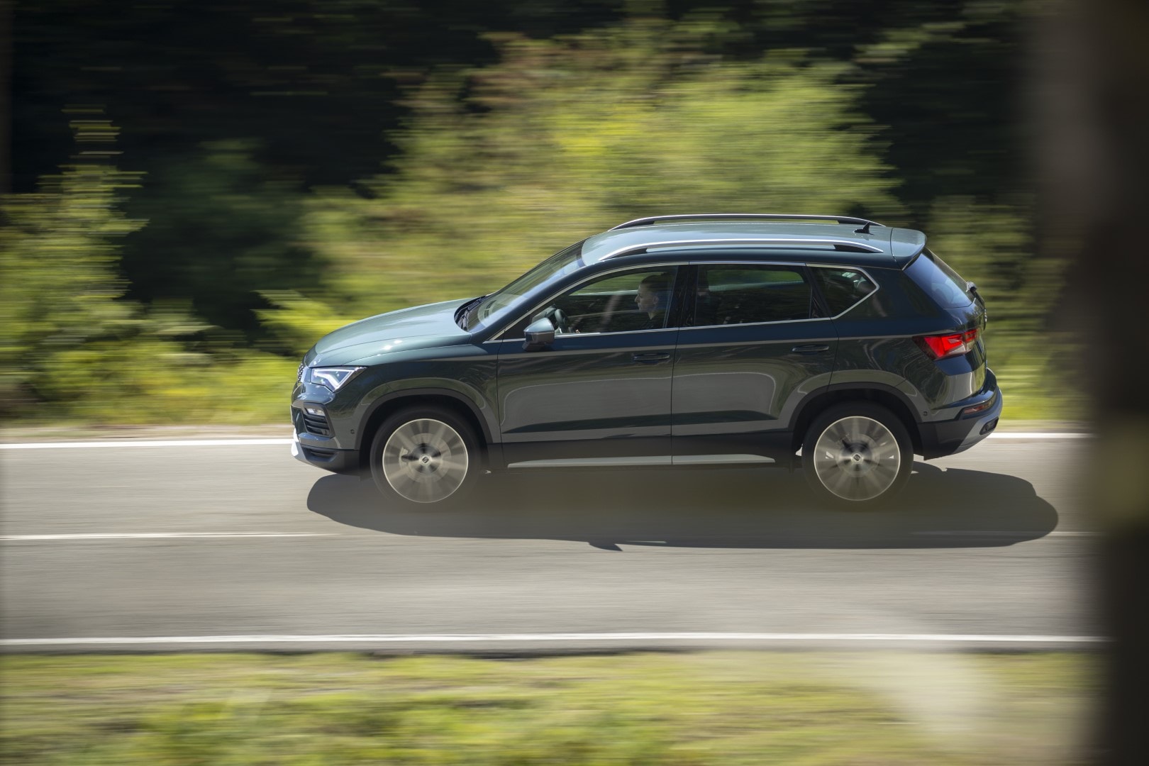 Lateral del SEAT Ateca captado en pleno dinamismo por una carretera forestal.
