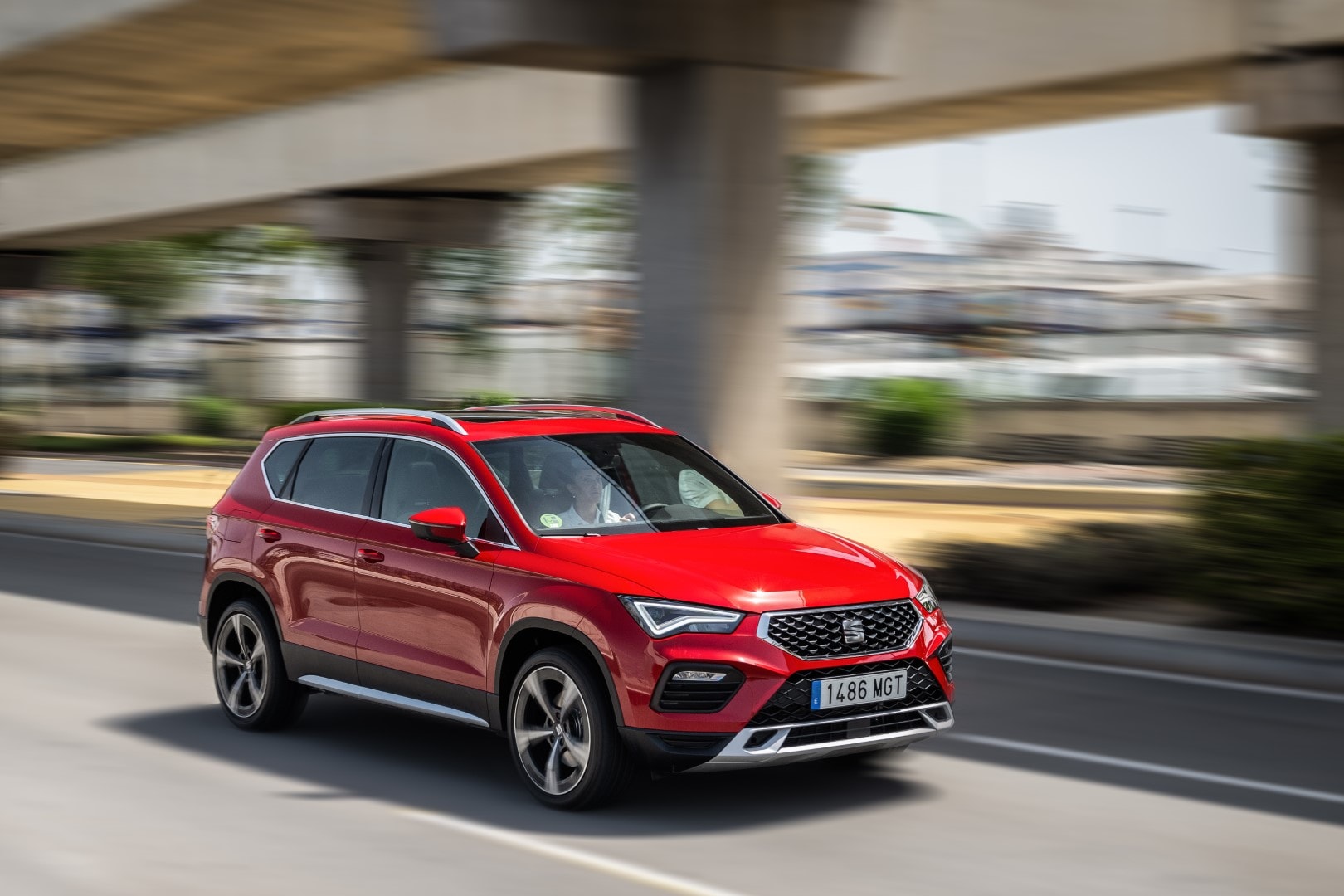 SEAT Ateca en color rojo, capturado en un entorno urbano en plena aceleración.