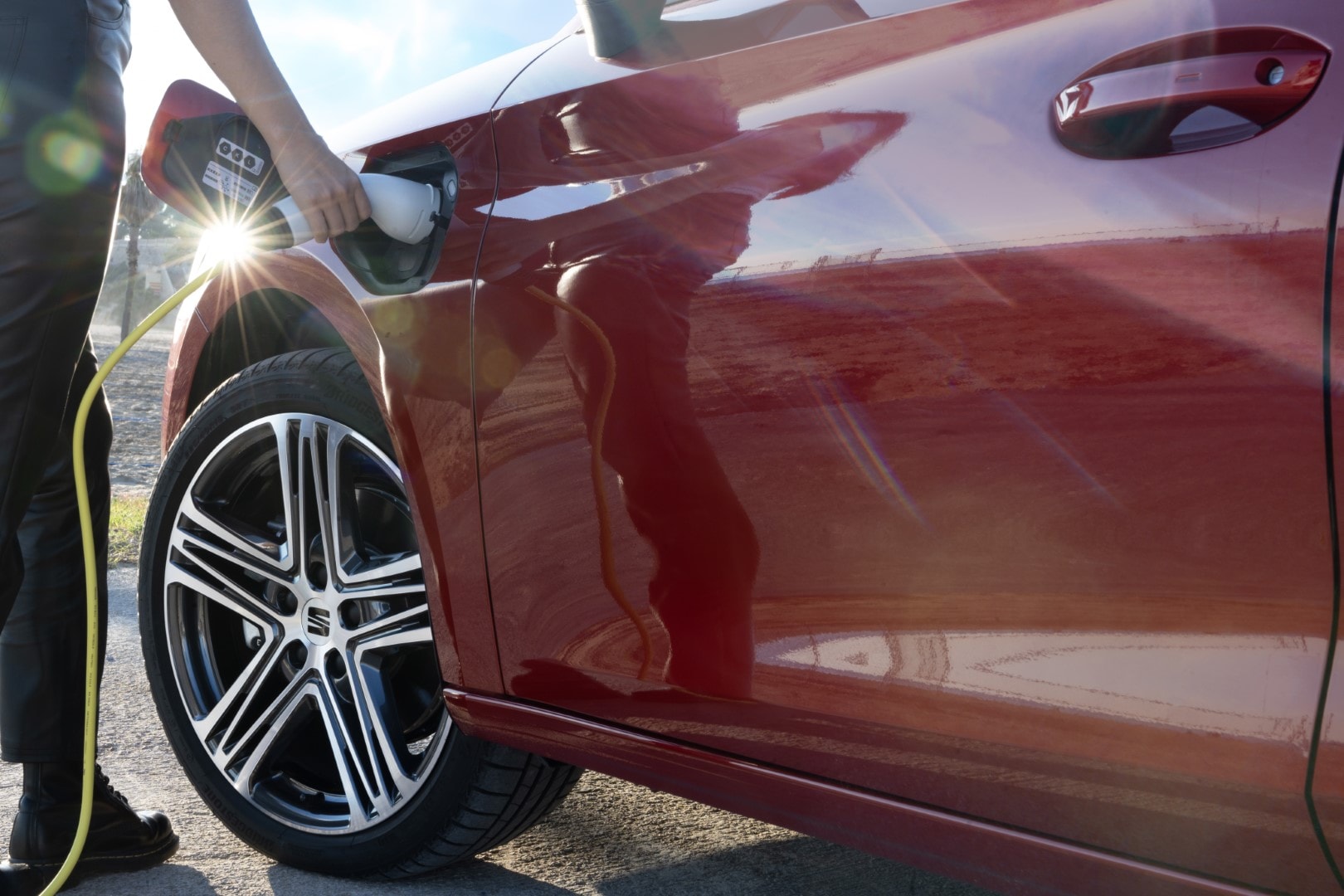 SEAT León Híbrido estacionado junto a una estación de carga, mostrando su diseño moderno y funcional.