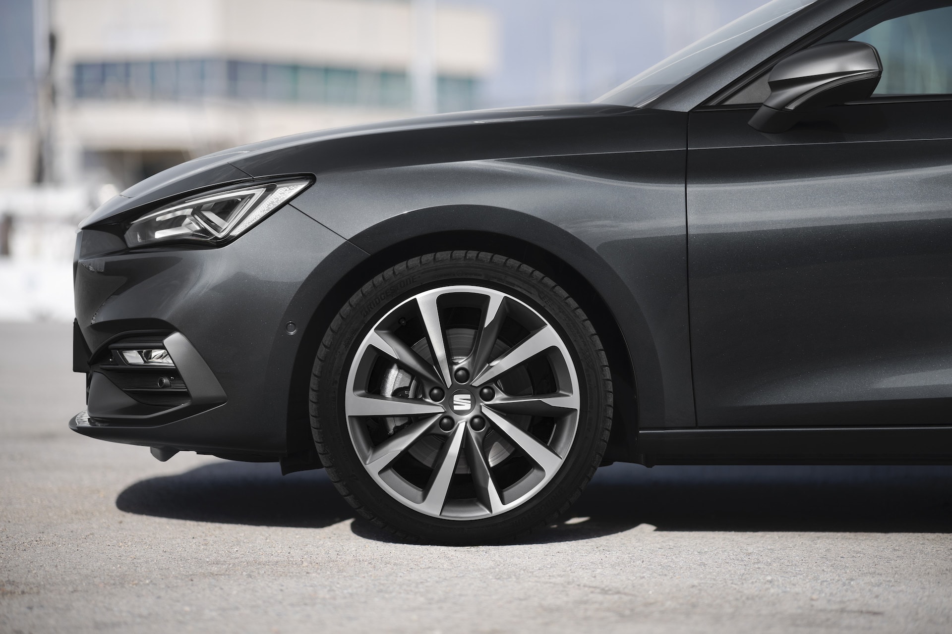 Vista del SEAT León al salir de un garaje. Refleja su diseño elegante.