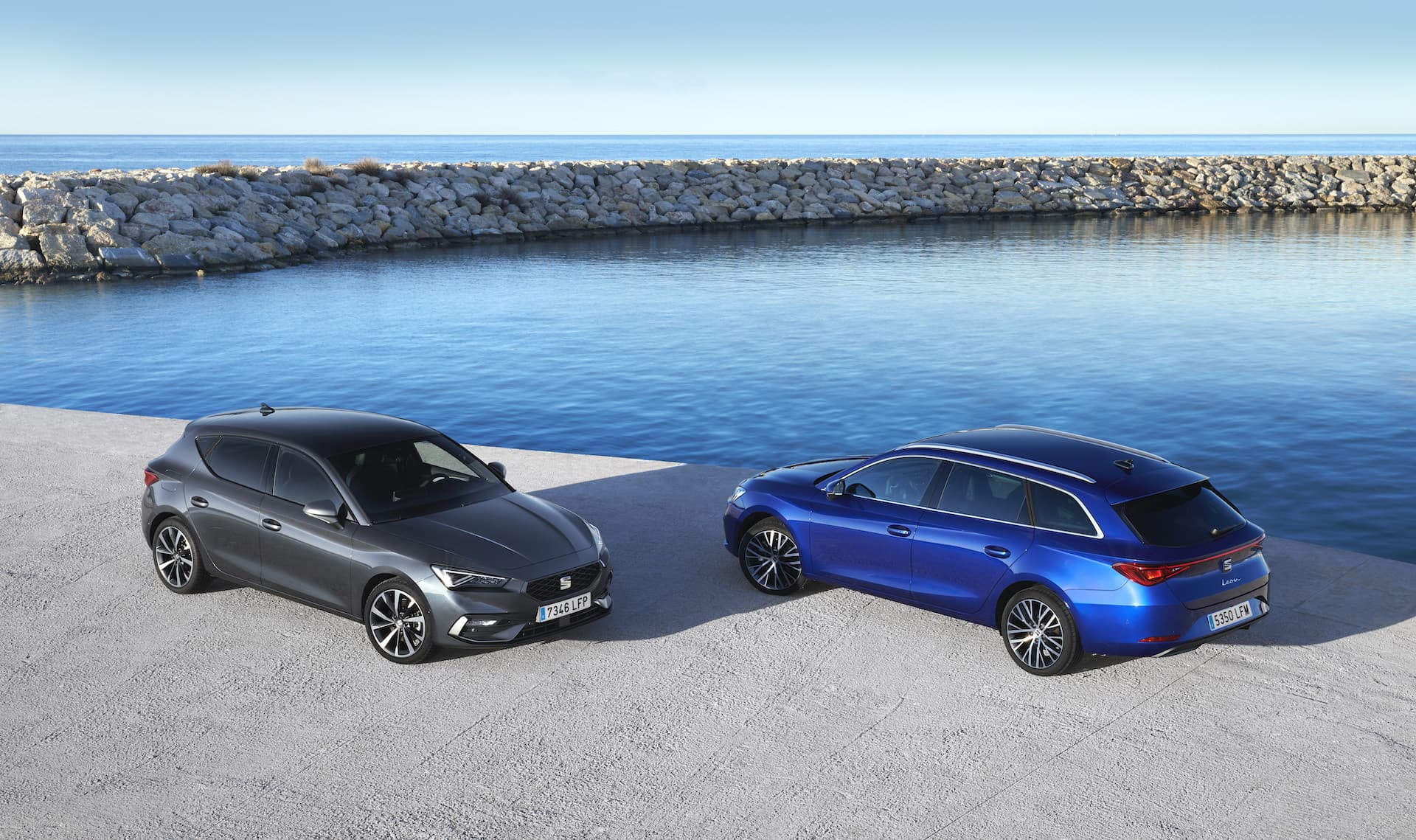 SEAT León rojo y azul junto a yates, resaltando su elegancia.