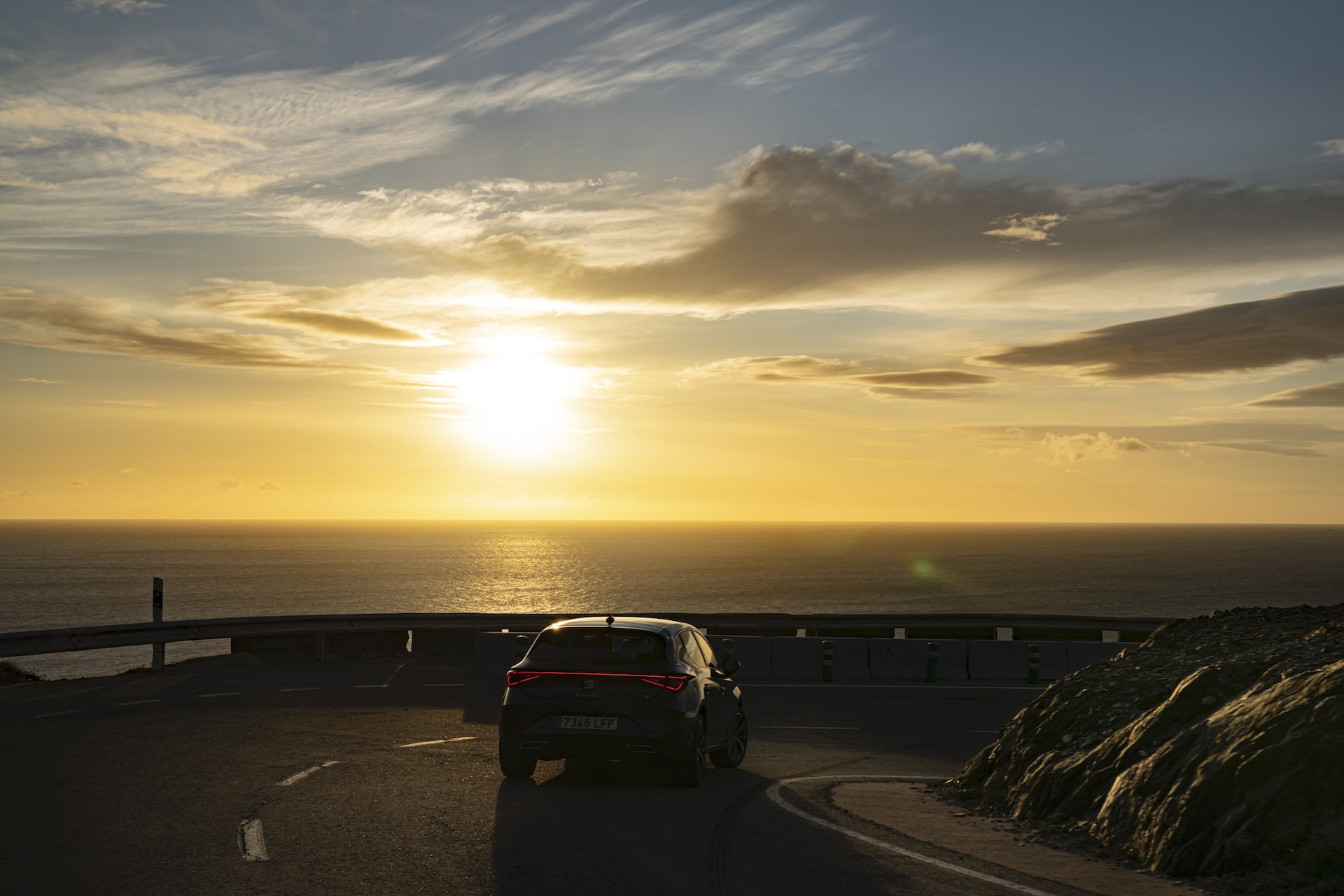 El SEAT León recorriendo una curva costera al atardecer, combinación de estilo y rendimiento.