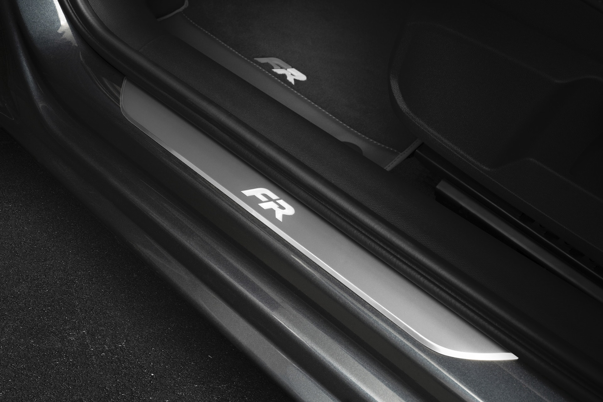 Detalle del umbral de puerta del SEAT León con insignia FR, una nota de deportividad en el interior.