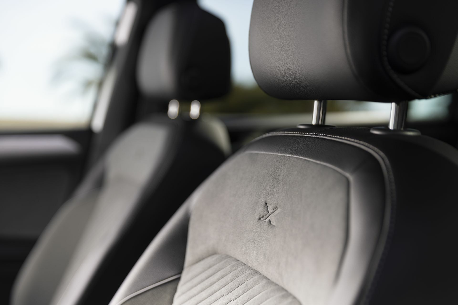Detalle de la textura y calidad del asiento trasero con el logo del fabricante.