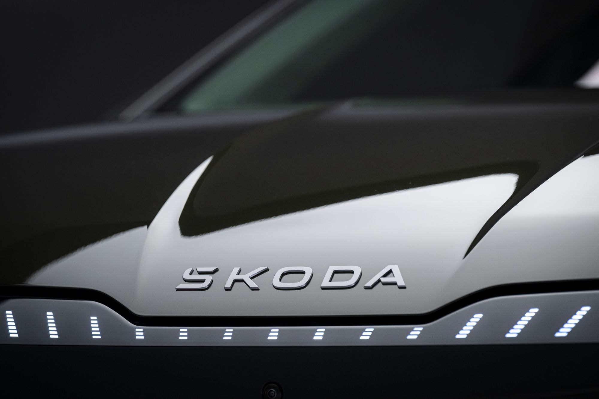 Vista detallada del logo Skoda en el Enyaq iV, que resalta su elegancia.