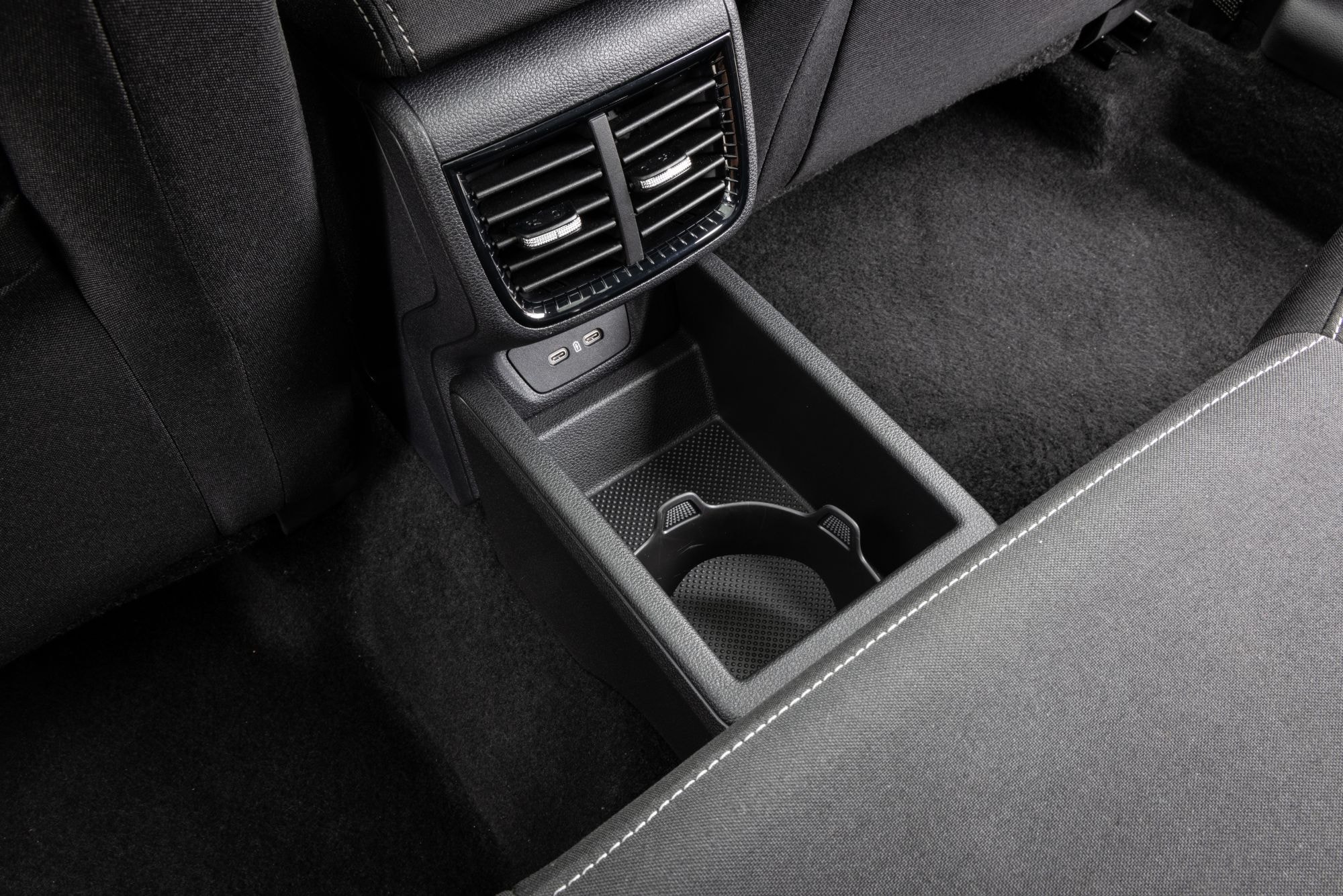Compartimento trasero con portavasos y ventilación, ideal para mayor comodidad.