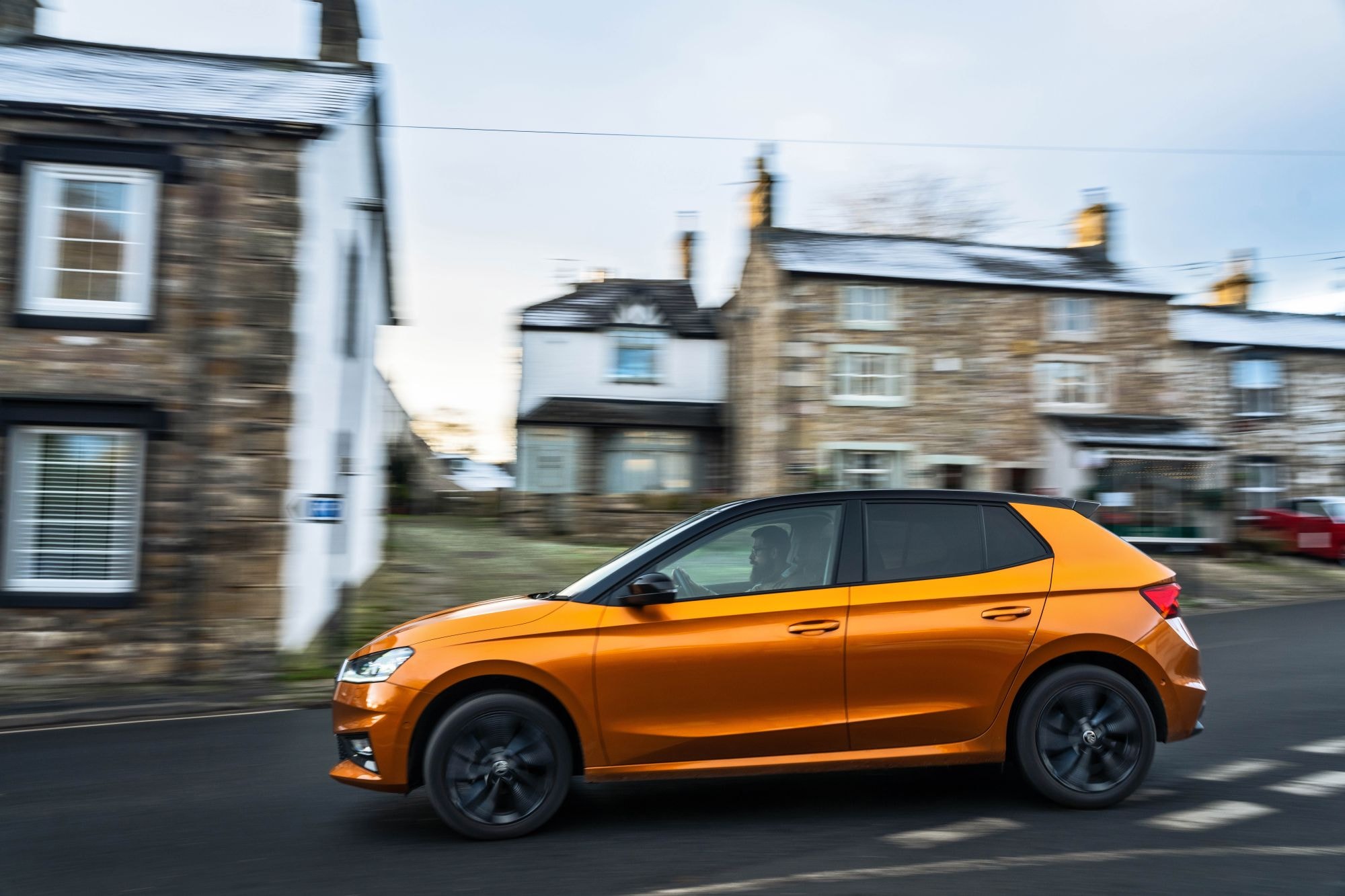 El Skoda Fabia en movimiento por una ruta escénica, que destaca su diseño atractivo.
