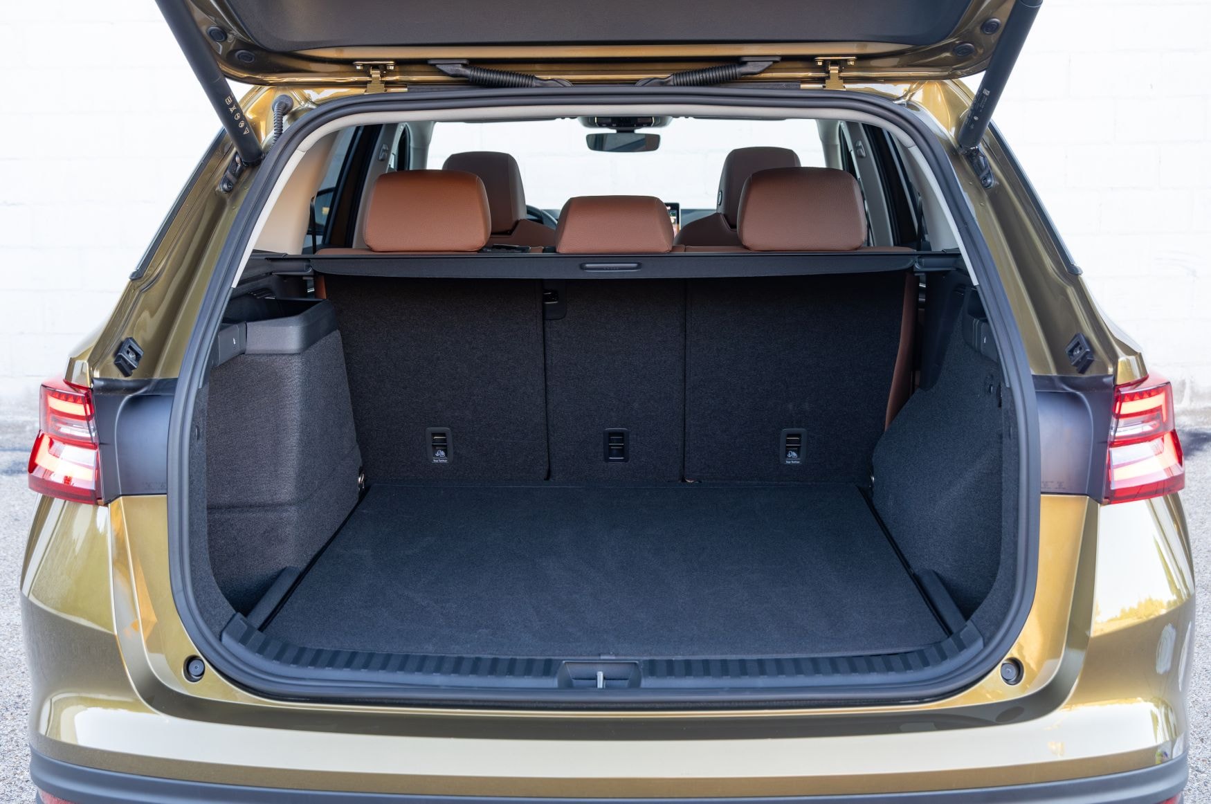 Vista lateral del Skoda Kodiaq híbrido en un entorno arquitectónico moderno.