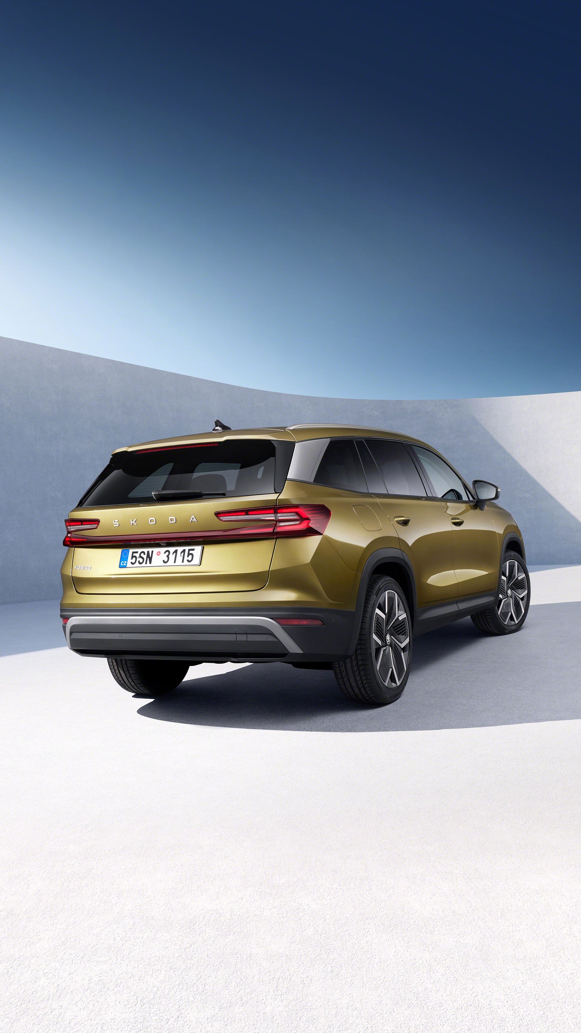 Vista lateral y trasera del Skoda Kodiaq dorado, mostrando su amplia carrocería.