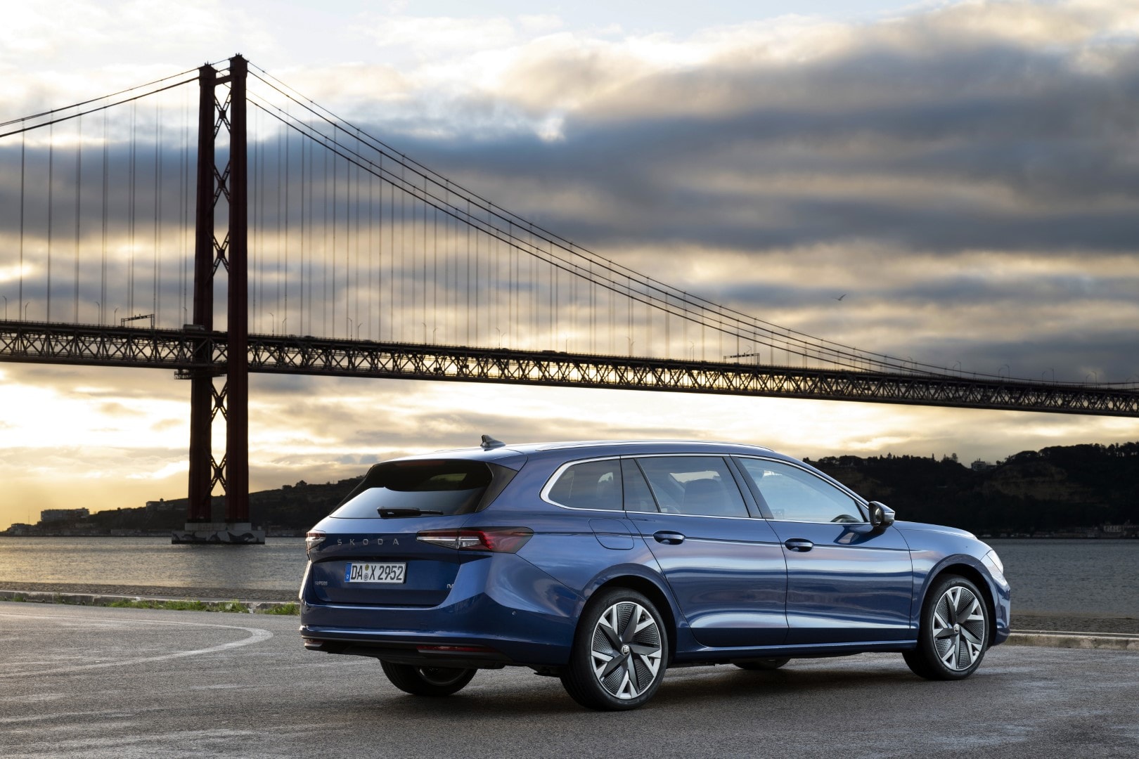 Vista lateral y trasera del Superb Combi con el puente de fondo, mostrando su estética.