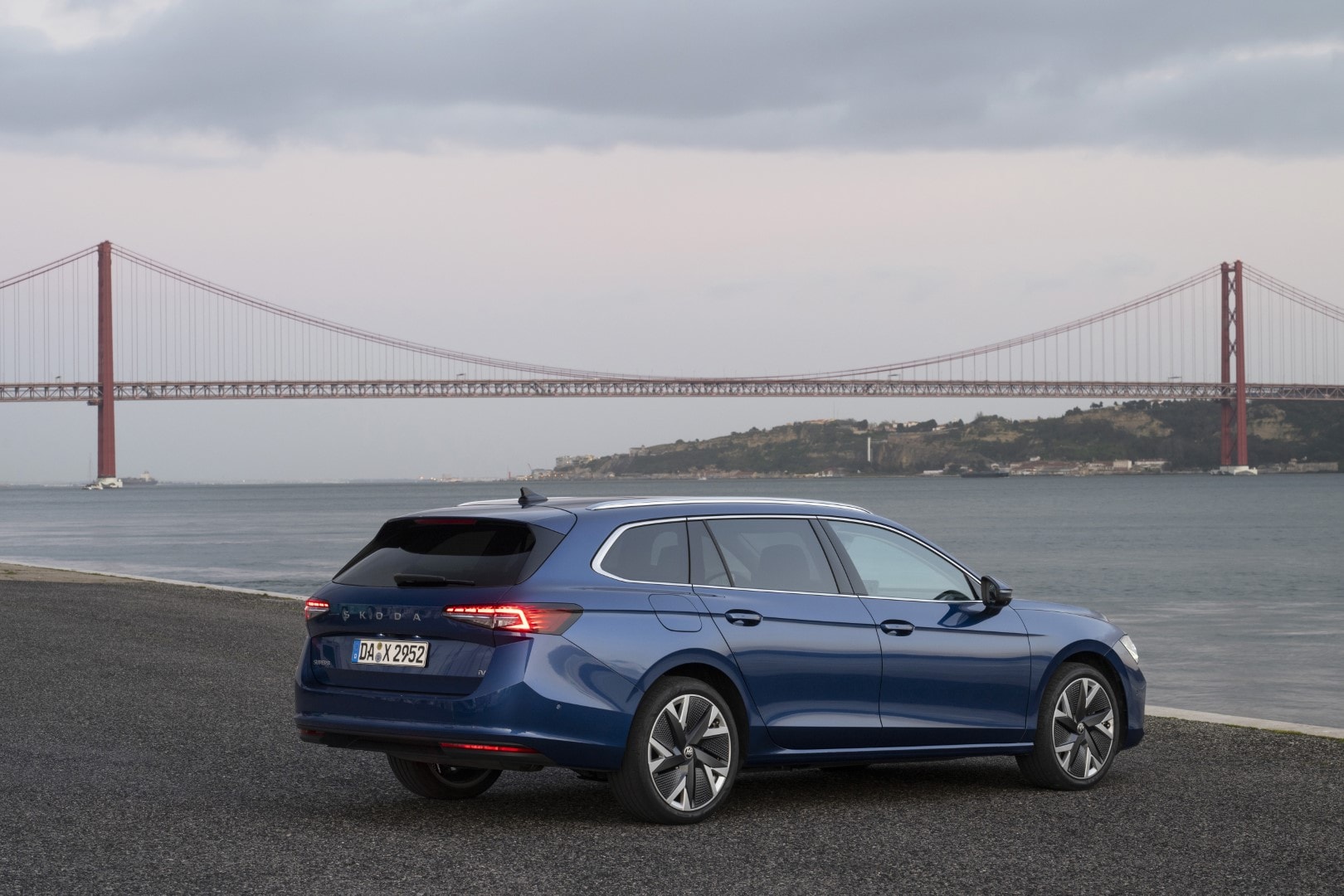 Silueta lateral y trasera del Skoda Superb Combi con paisaje costero.