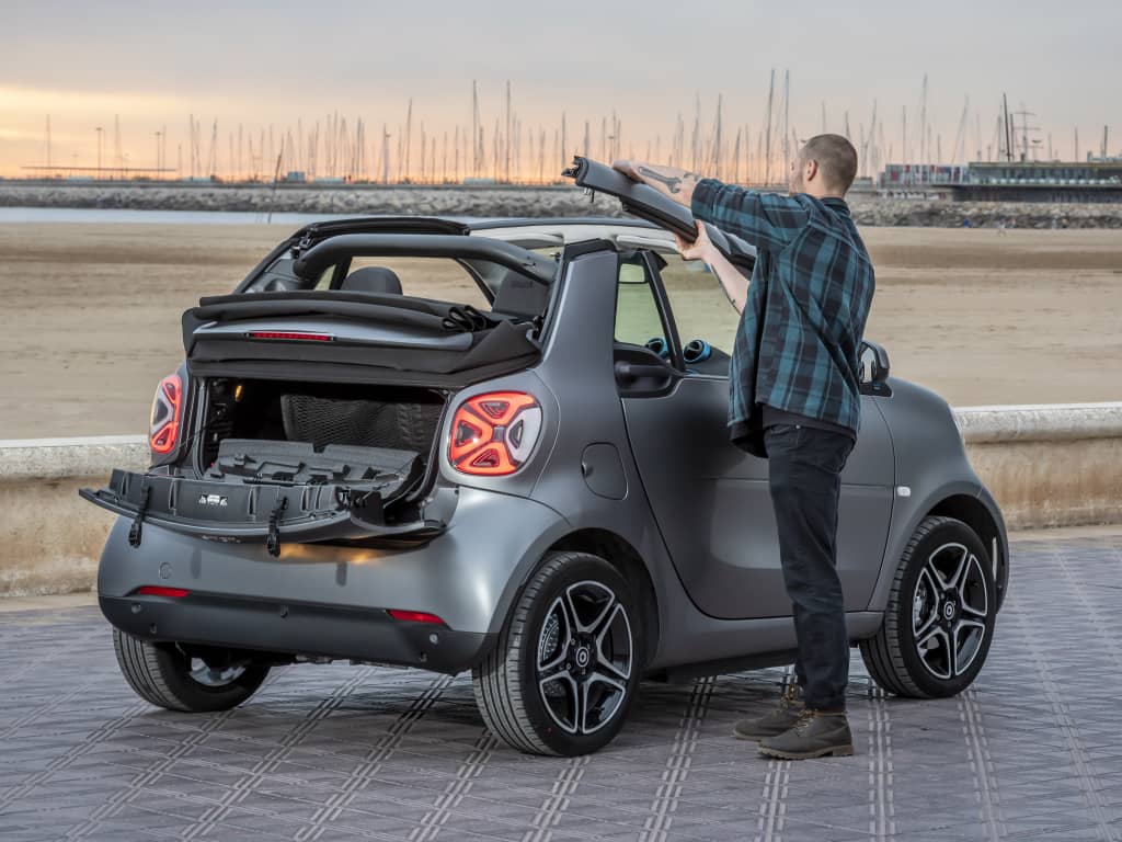Smart Fortwo Cabrio mostrando su sistema de techo retráctil con usuario.