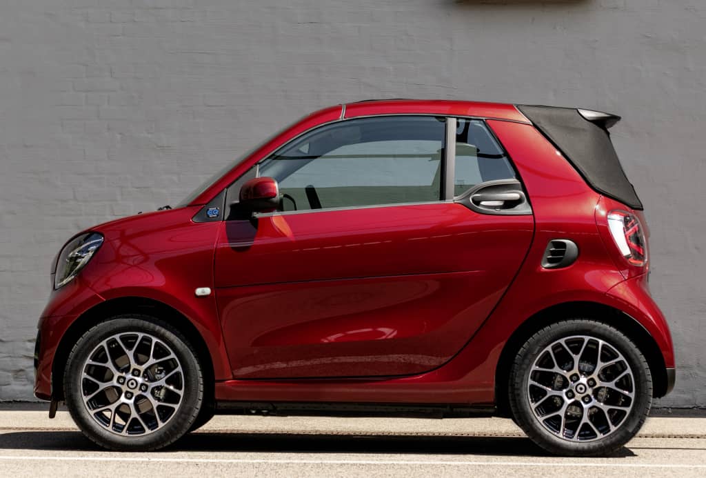 Smart EQ Fortwo Cabrio en rojo con techo abierto, vista lateral.