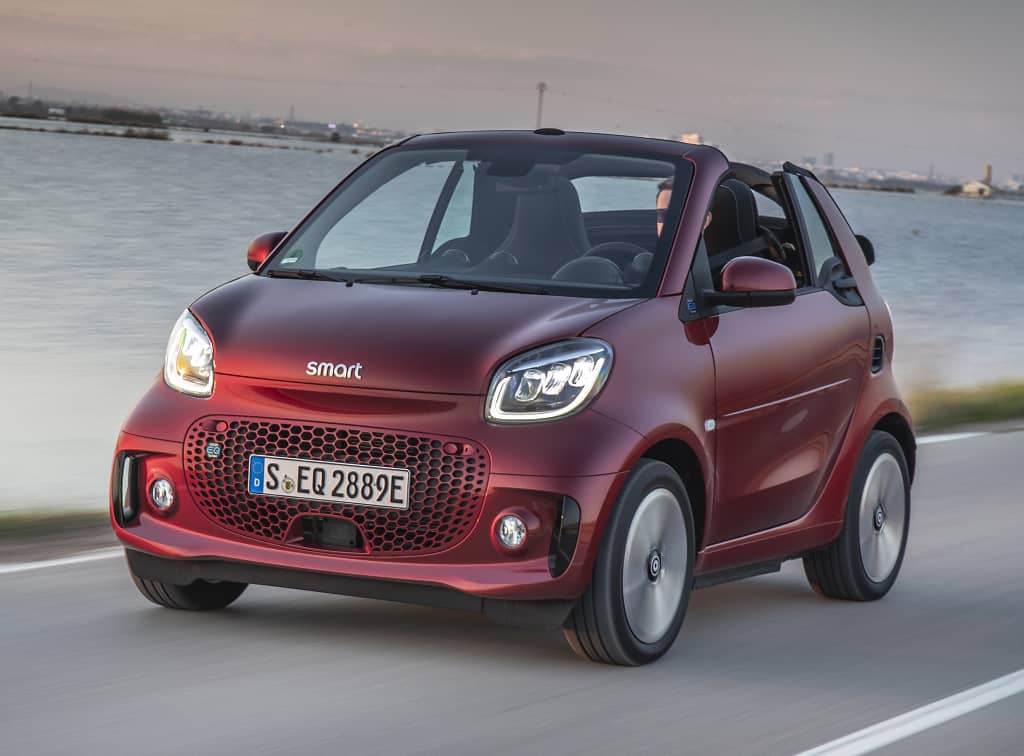 Smart EQ Fortwo Cabrio rojo en movimiento, destacando su techo.