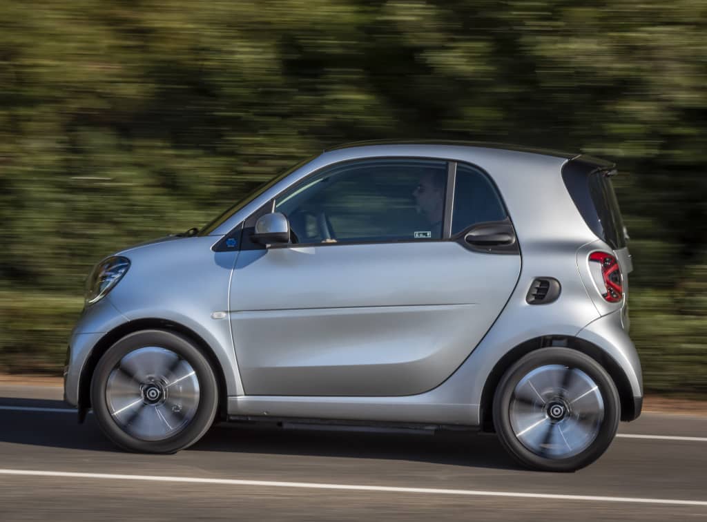 Perfil del Smart EQ Fortwo, destacando su diseño lateral mientras conduce.