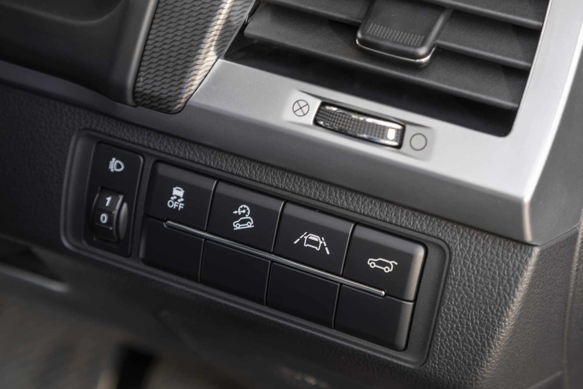 Botonera de comandos para ajustes del vehículo y tecnologías de confort.
