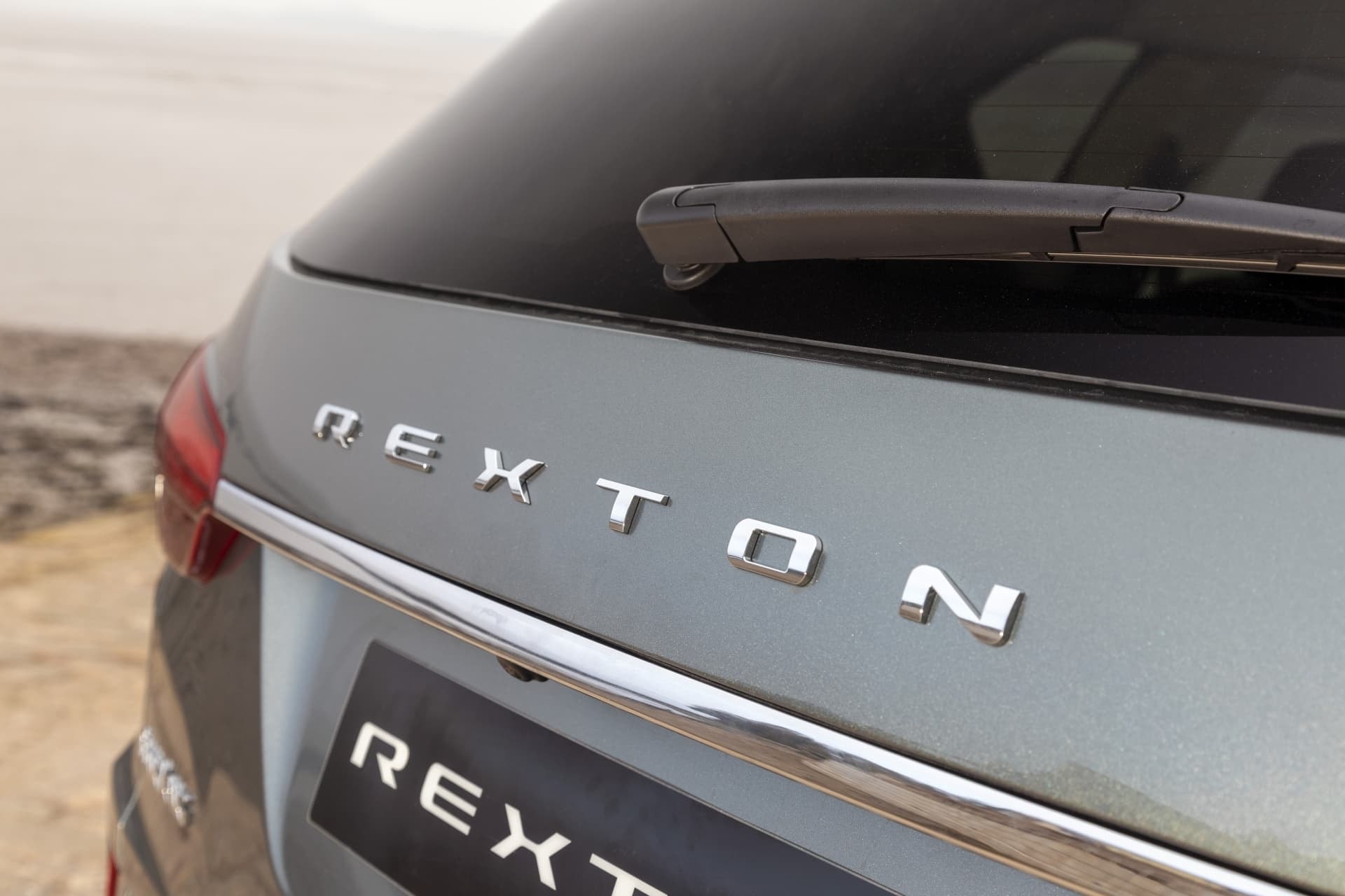 Letras distintivas "REXTON" en el portón trasero, identidad del modelo.