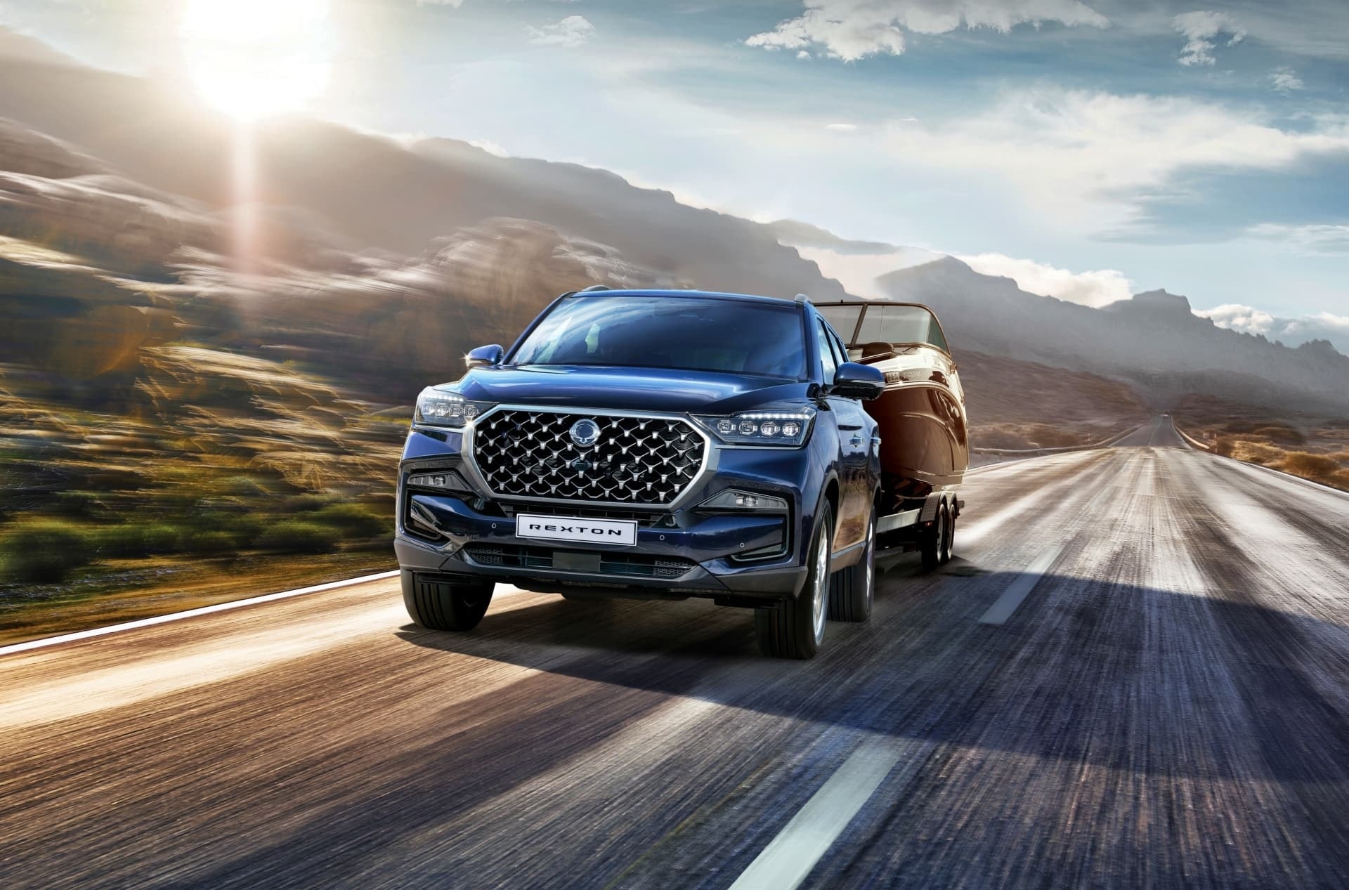 Vista frontal del Rexton remolcando un carro en carretera.
