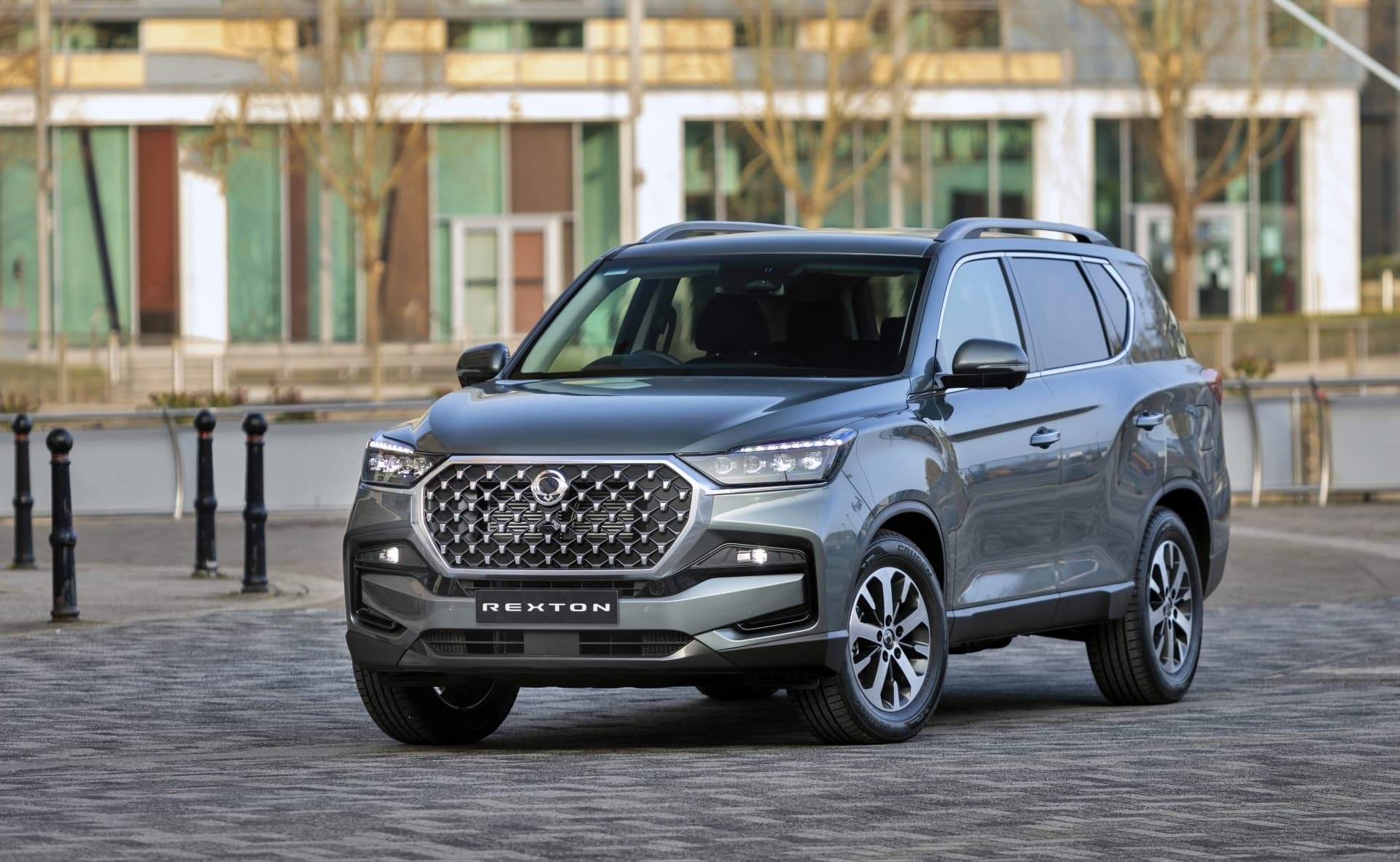 Vista angular delantera del Rexton en un entorno urbano moderno.