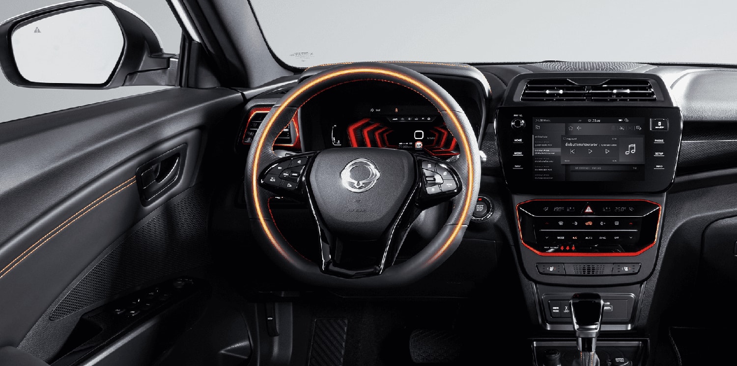 Cuadro de mandos y volante del SsangYong Tívoli con acabados en naranja.