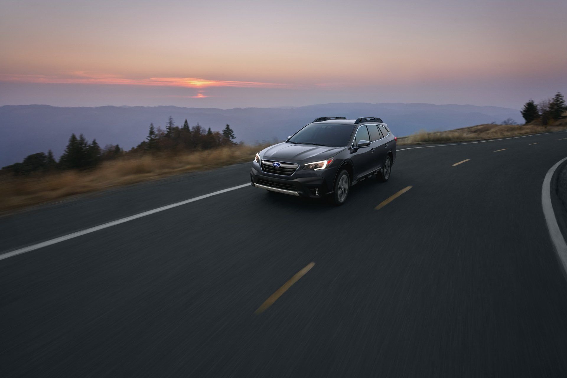 El Subaru Outback en movimiento, capturado al atardecer.