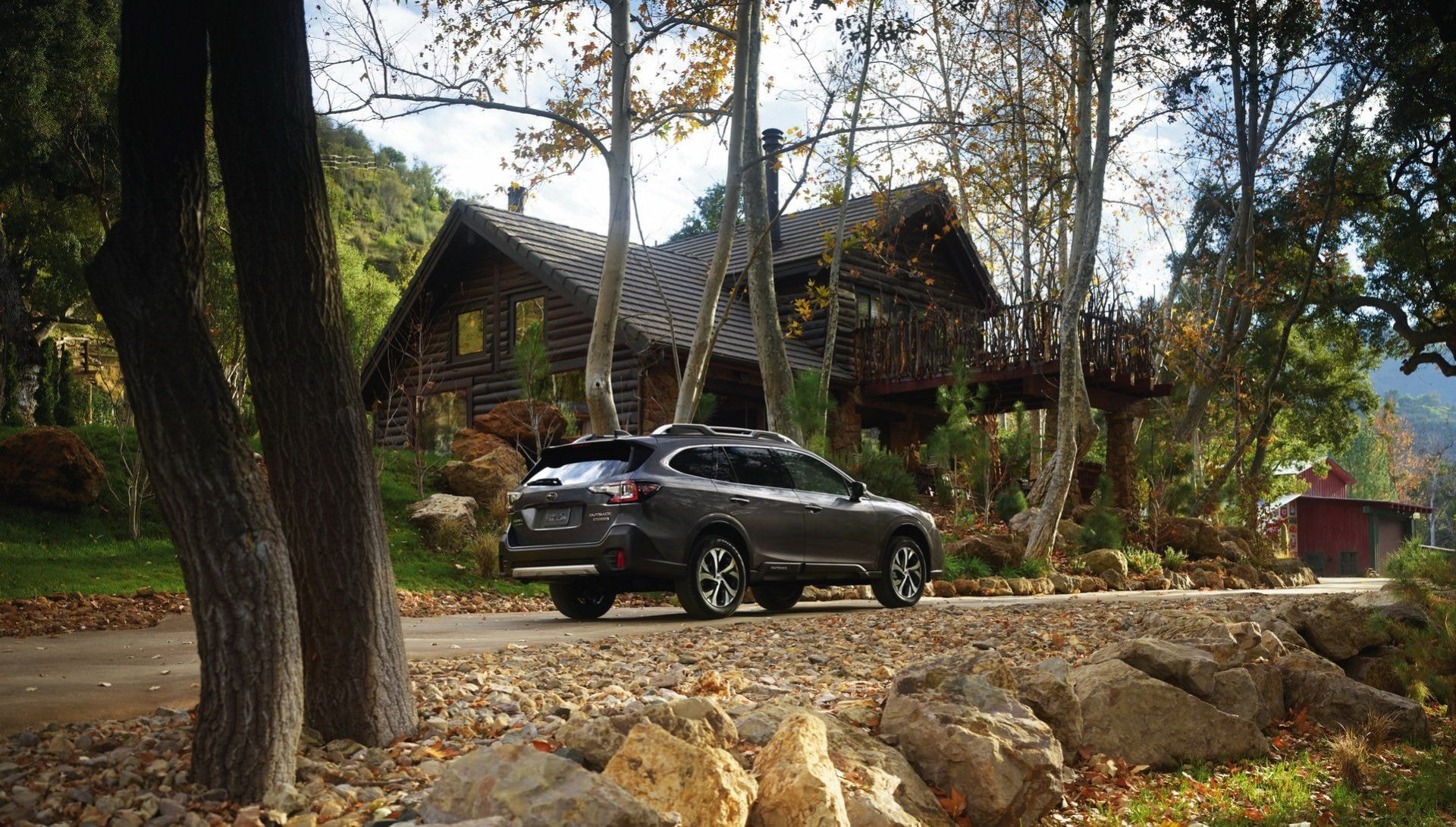 Subaru Outback estacionado cerca de una cabaña rústica, integrándose con la naturaleza.