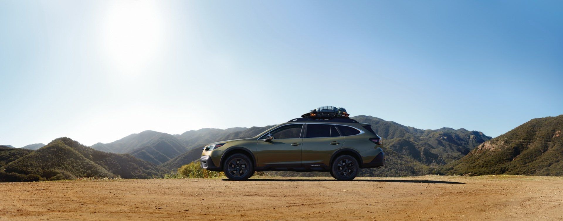 Perfil del Subaru Outback destacando su estatura y líneas en la montaña.