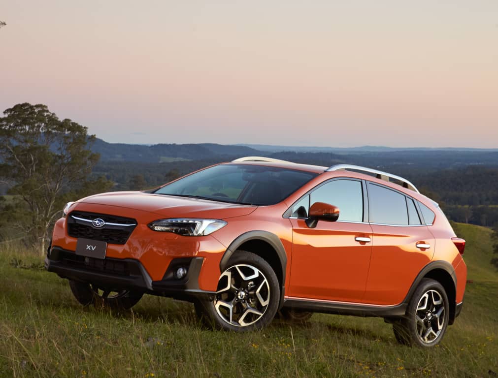 Vista delantera y lateral del Subaru XV en un atardecer campestre.