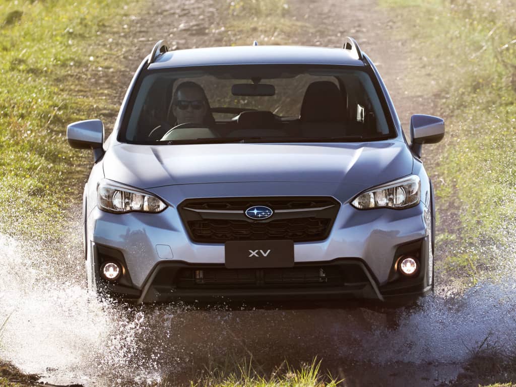 El Subaru XV atravesando un charco, mostrando su capacidad todoterreno.