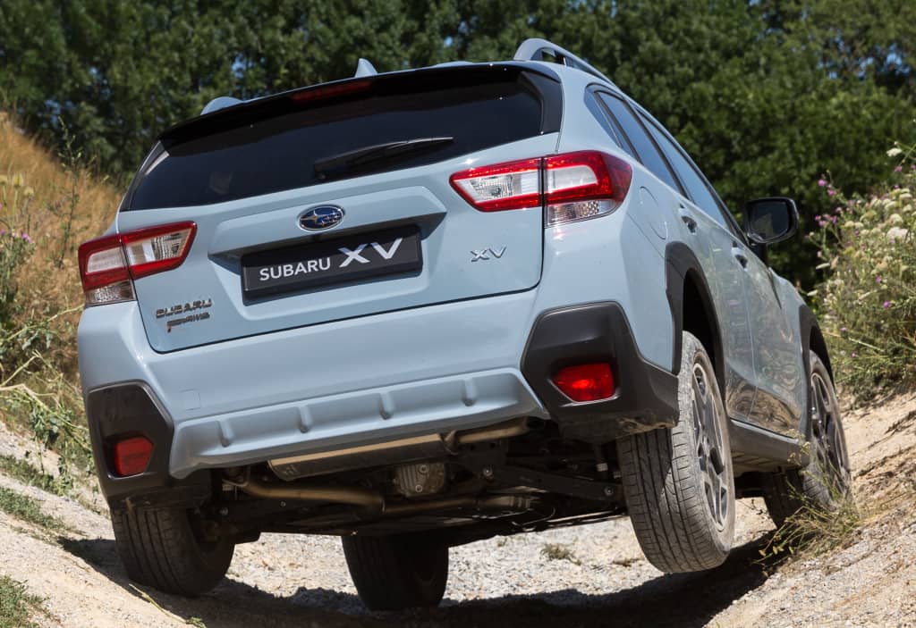 Subaru XV desde atrás en terreno rústico, mostrando robustez.