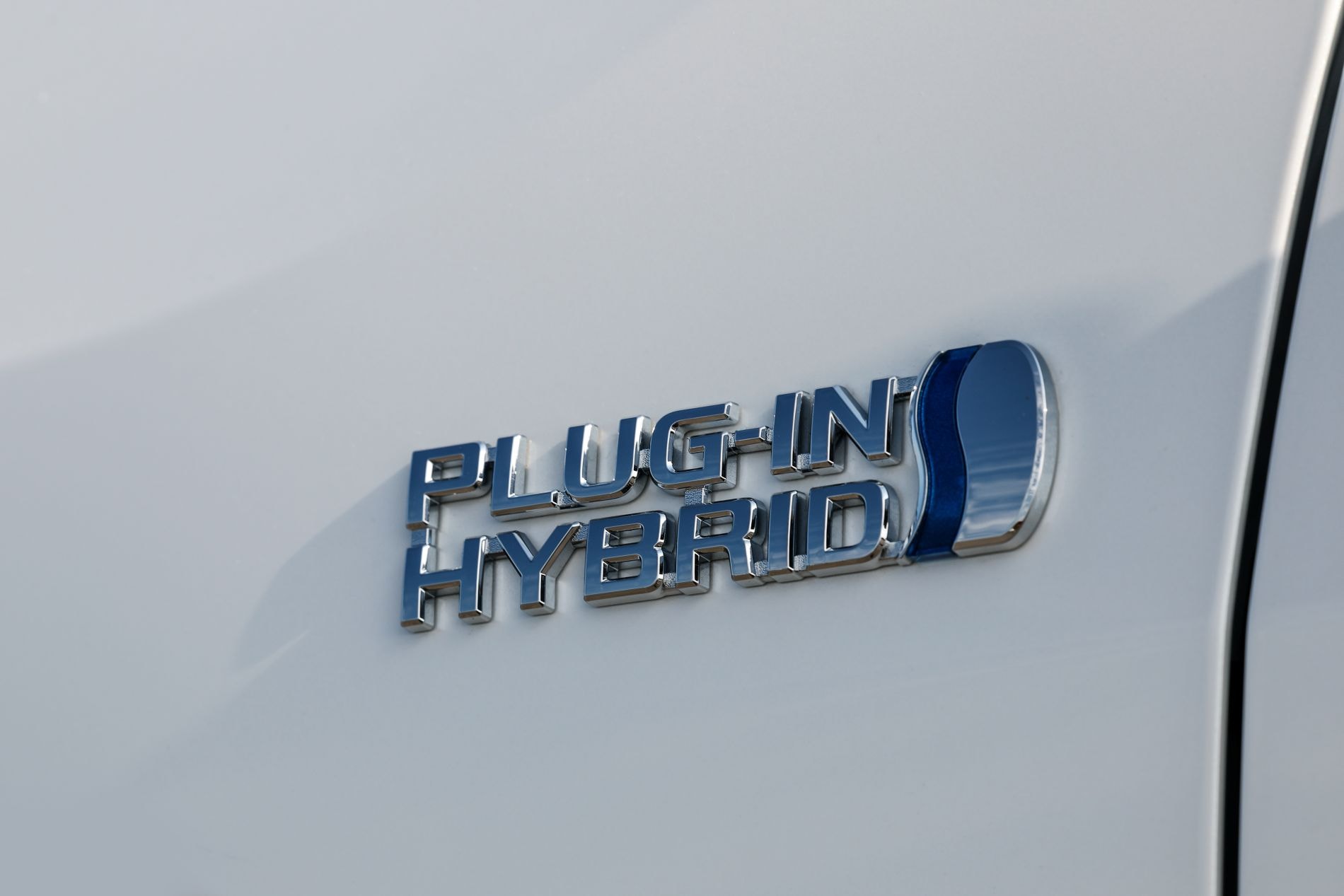 Vista lateral trasera de un Suzuki Across estacionado, mostrando líneas elegantes.