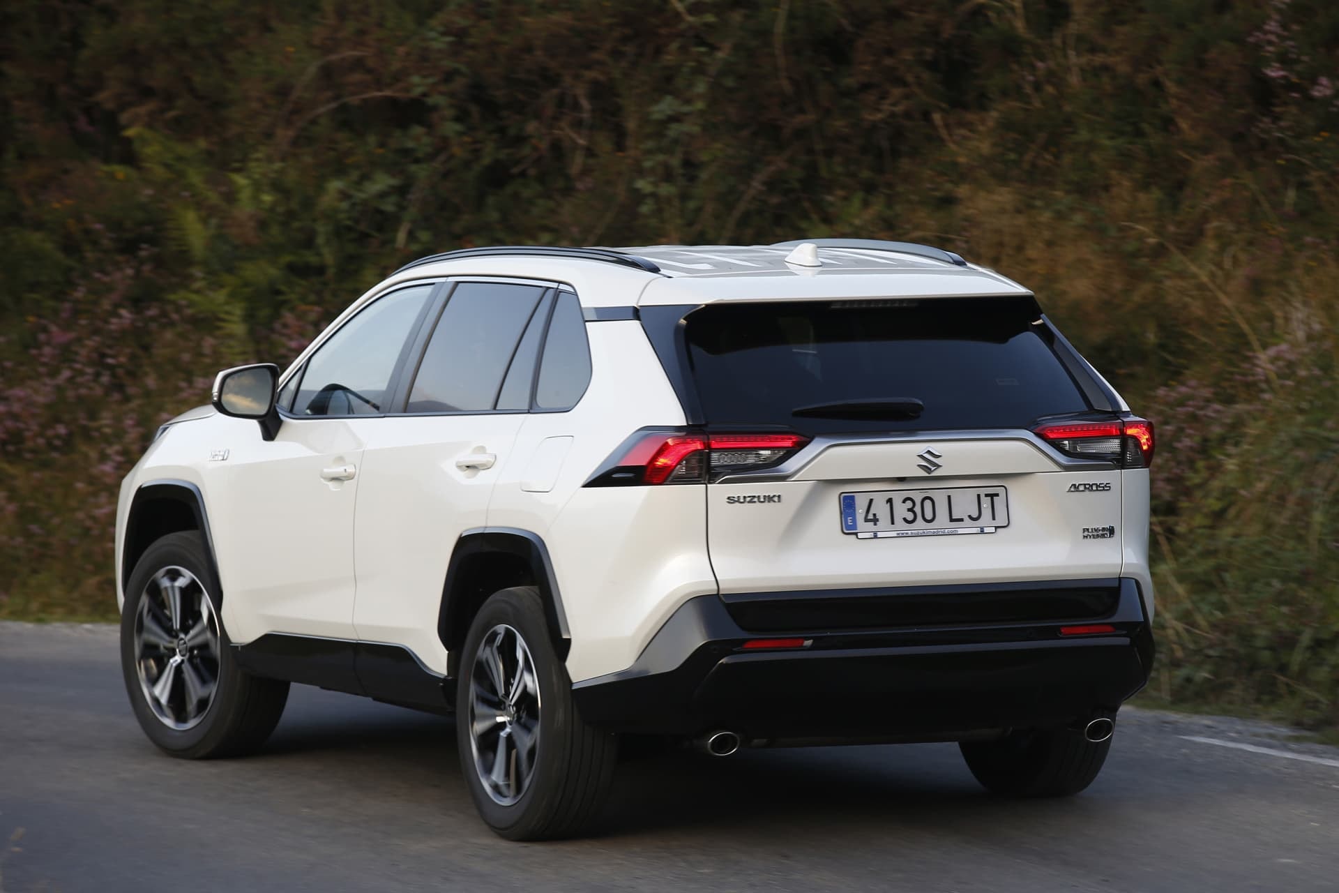 Toma trasera-lateral del Suzuki Across híbrido al salir del casco urbano.