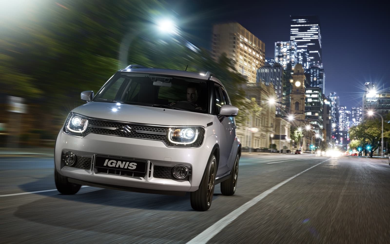 Suzuki Ignis iluminando la noche en el ambiente urbano.