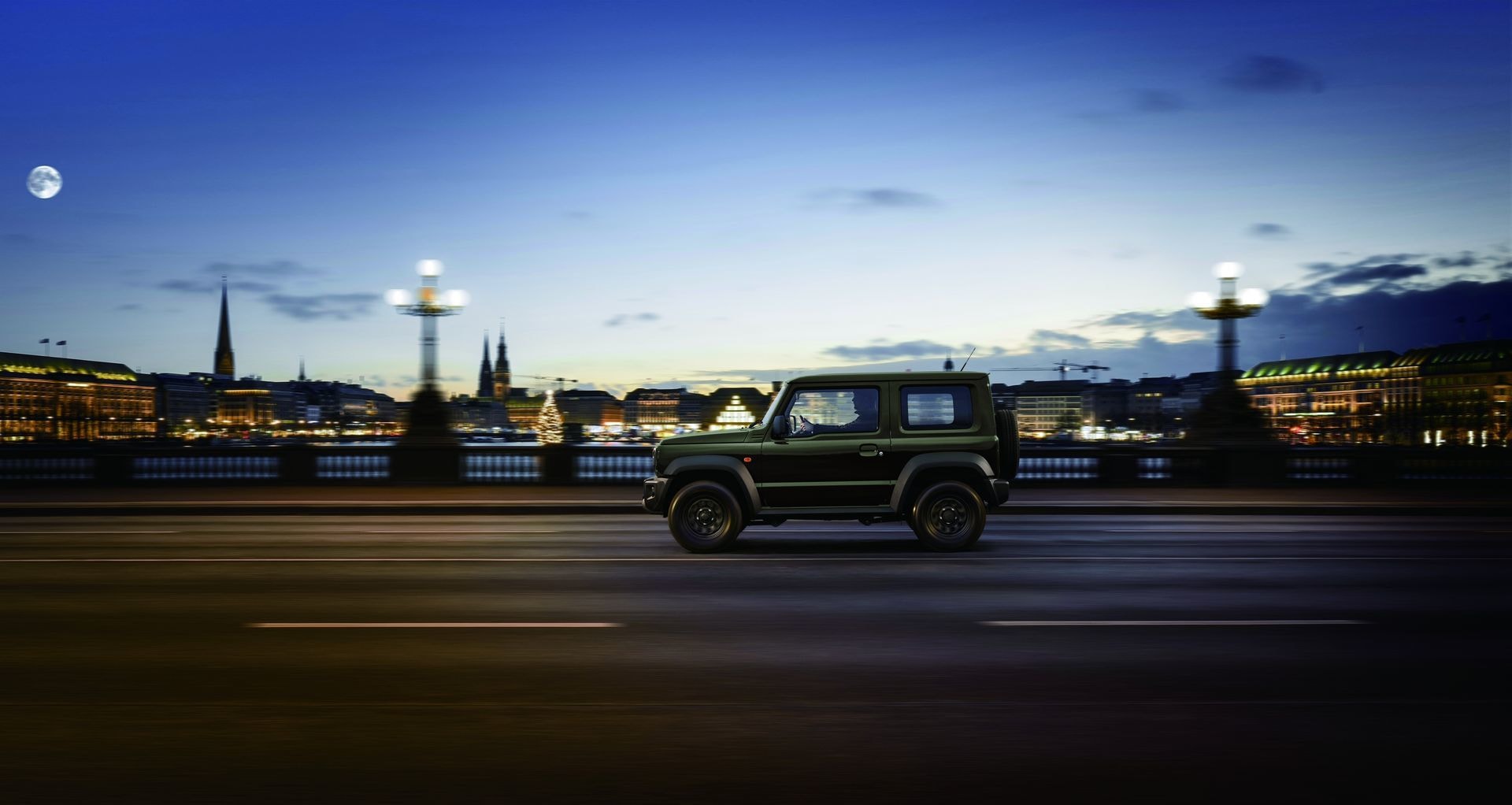 Imagen del Jimny PRO en movimiento por la ciudad al anochecer.