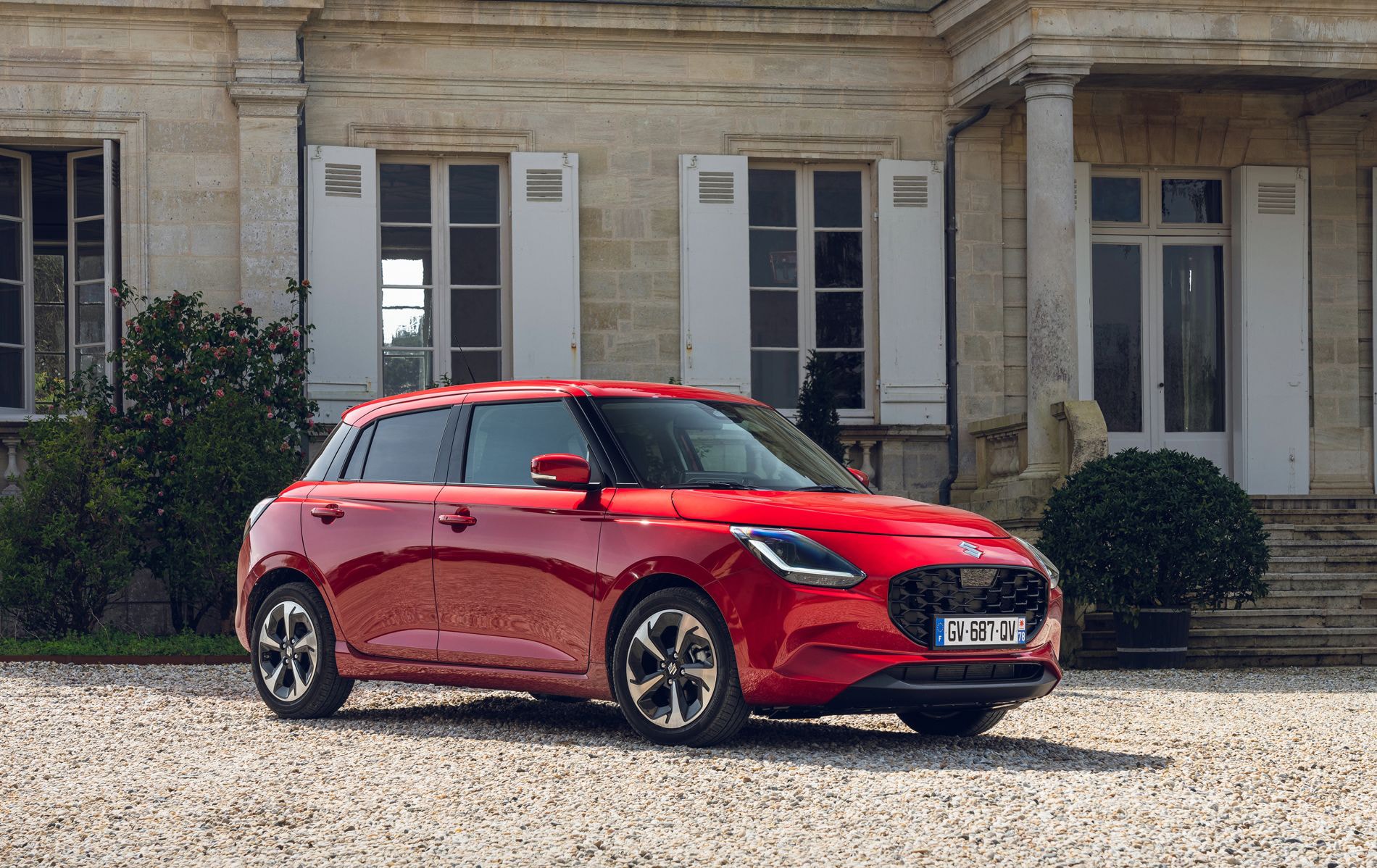 Perspectiva lateral del Suzuki Swift rojo, destaca su diseño moderno