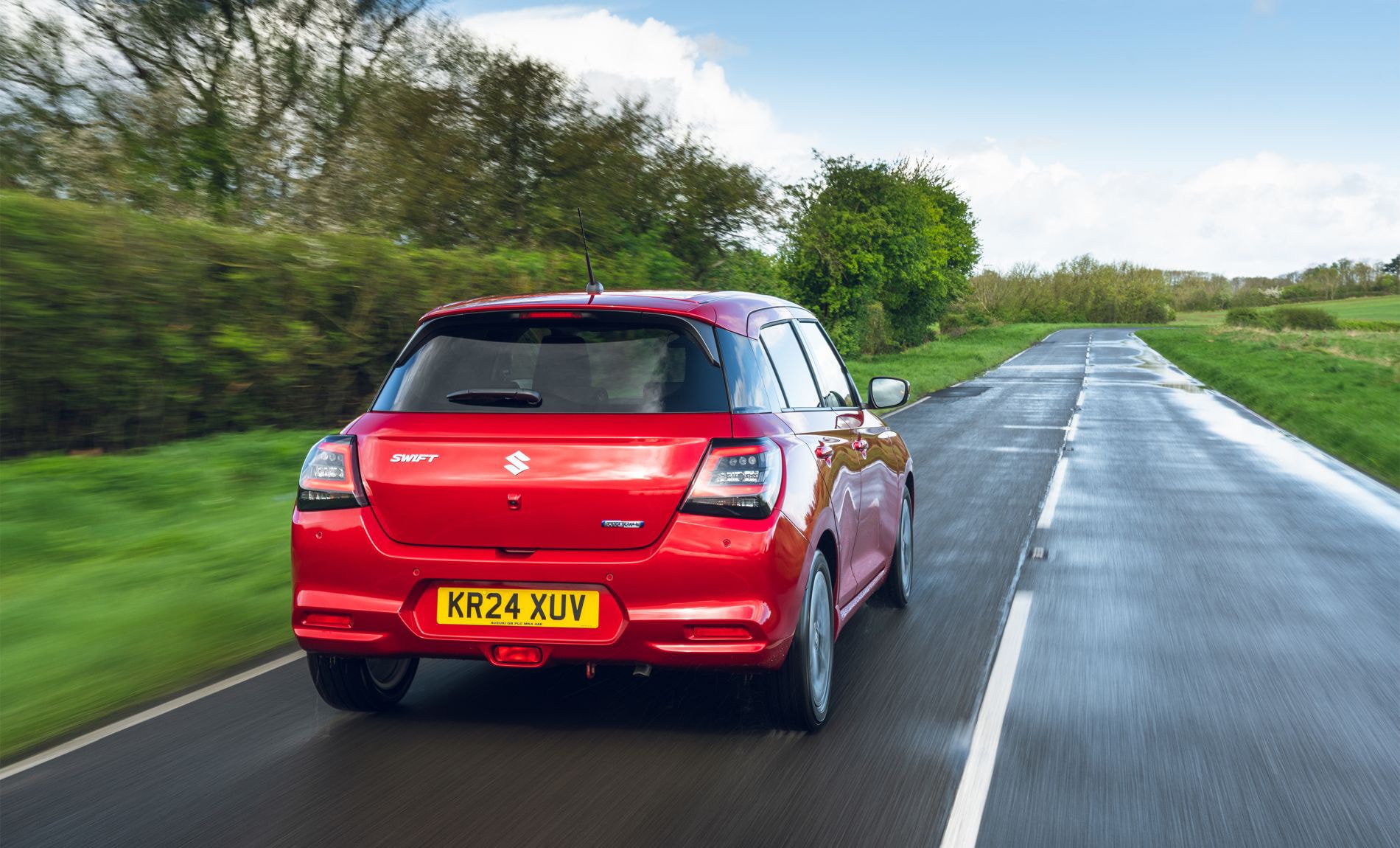 Imagen del Suzuki Swift en la carretera, resaltando su trasera en acción.