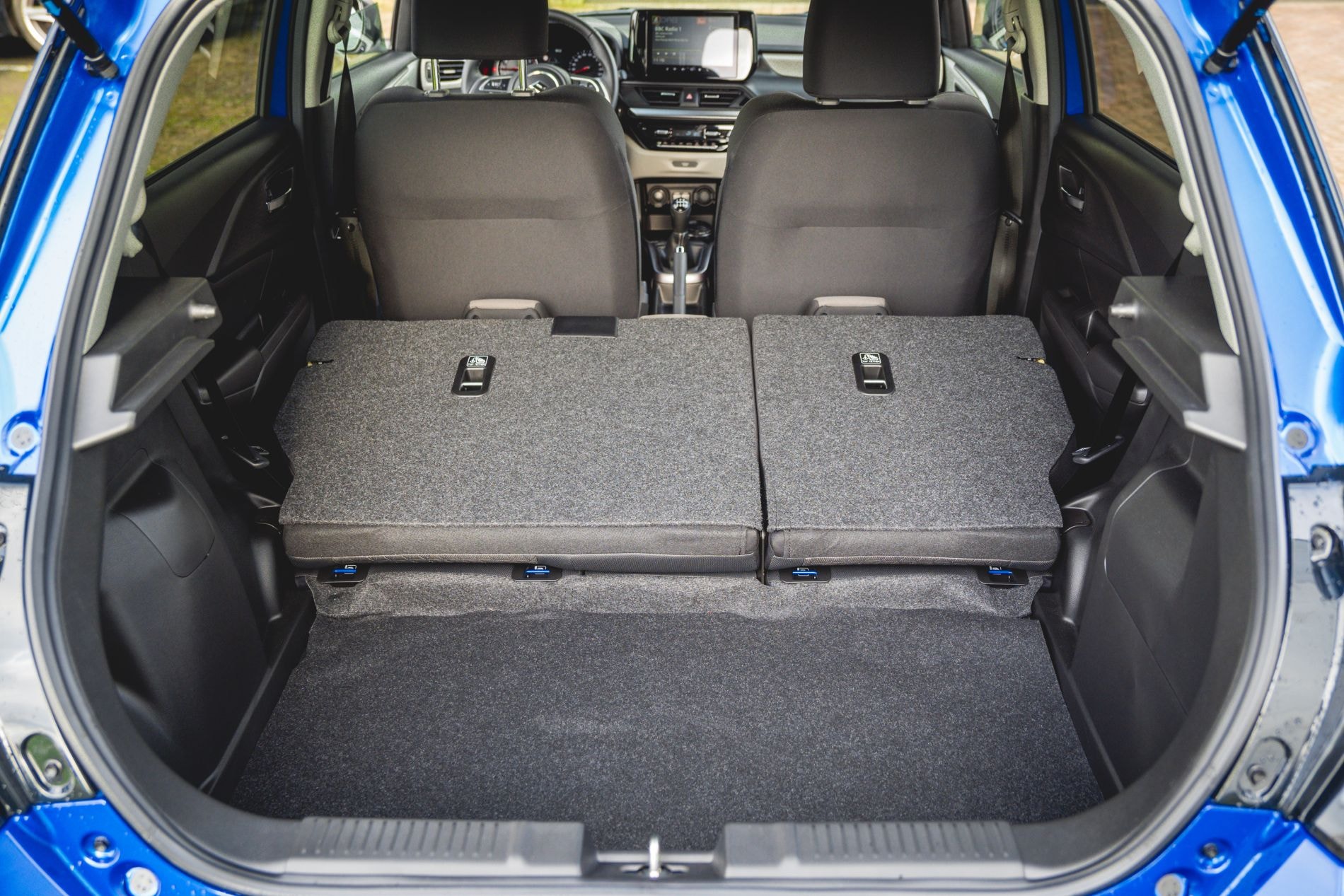 Vista del interior trasero, con asientos abatibles que maximizan el espacio.
