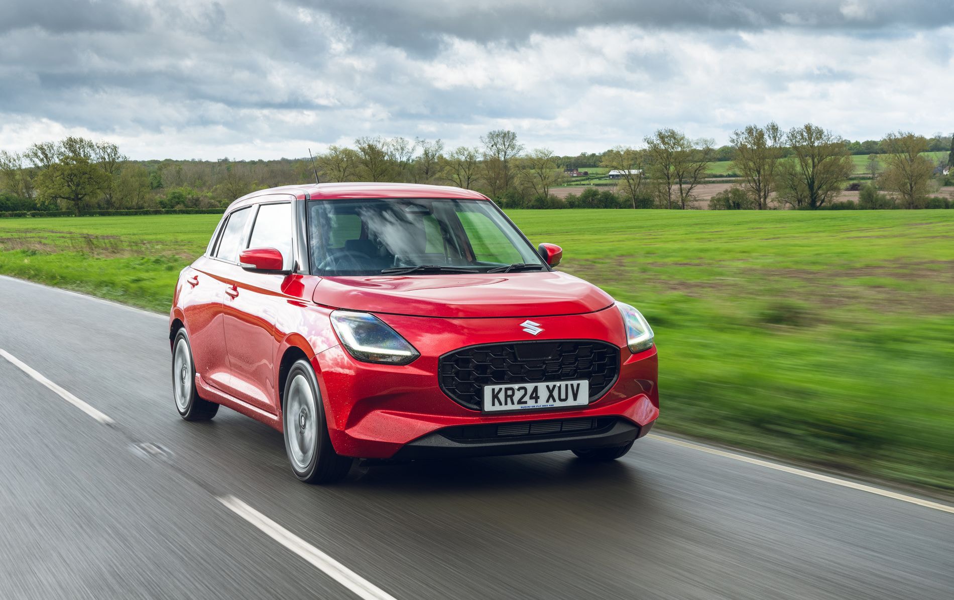 Vista trasera del Suzuki Swift en un camino rural, destacando su elegancia.