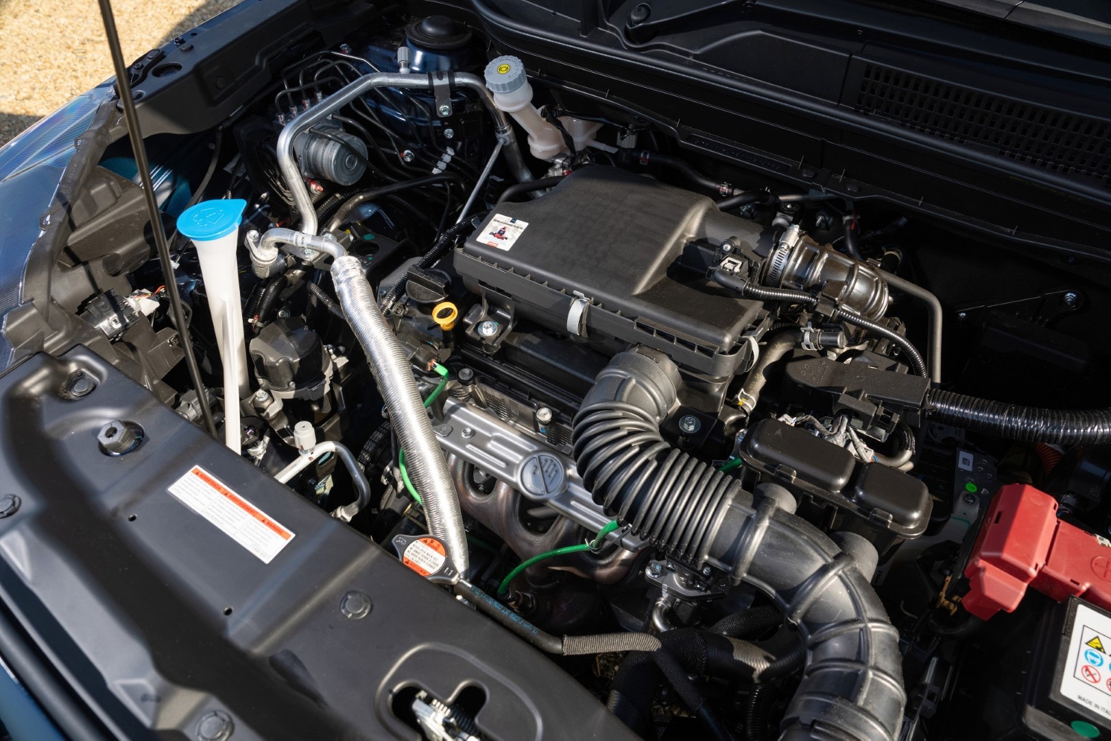 Detallada toma del motor híbrido del Suzuki S-Cross, mostrando componentes claves.