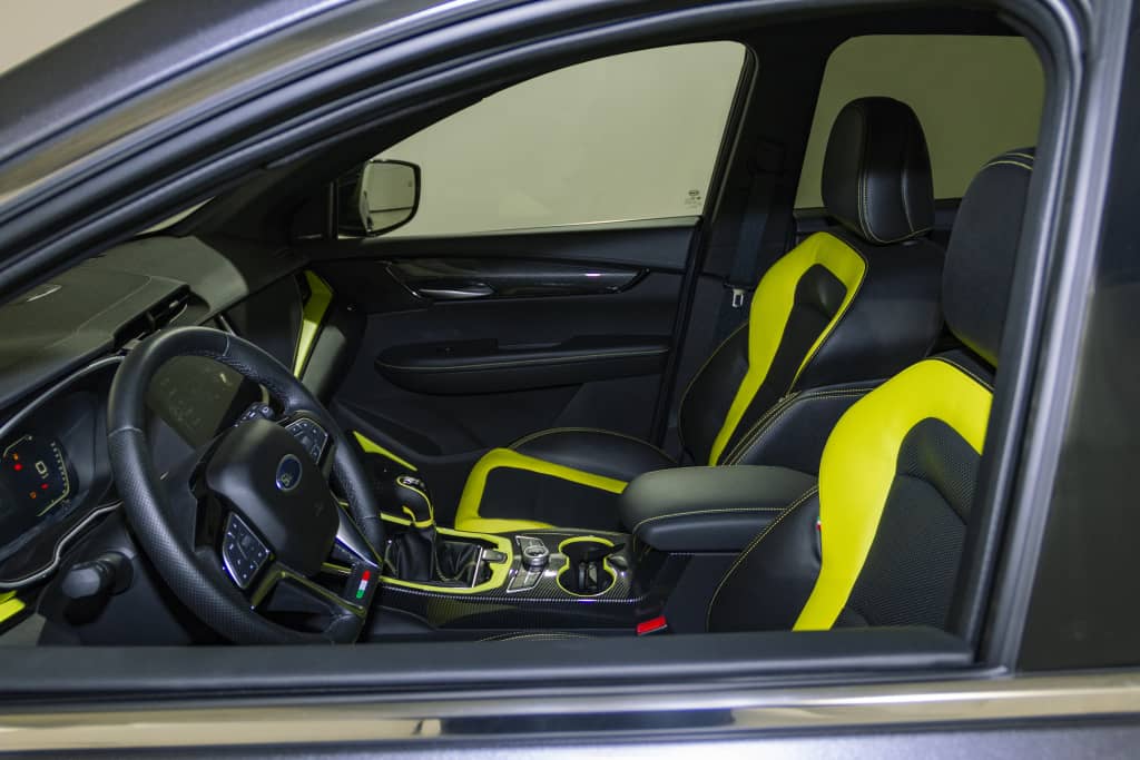 Interior deportivo del SWM G01 con acentos amarillos, confort y estilo.