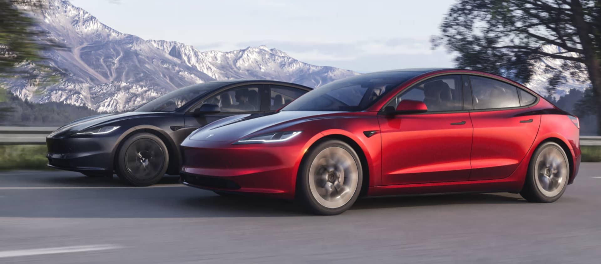 Model 3 rojo perfilado contra un skyline urbano.