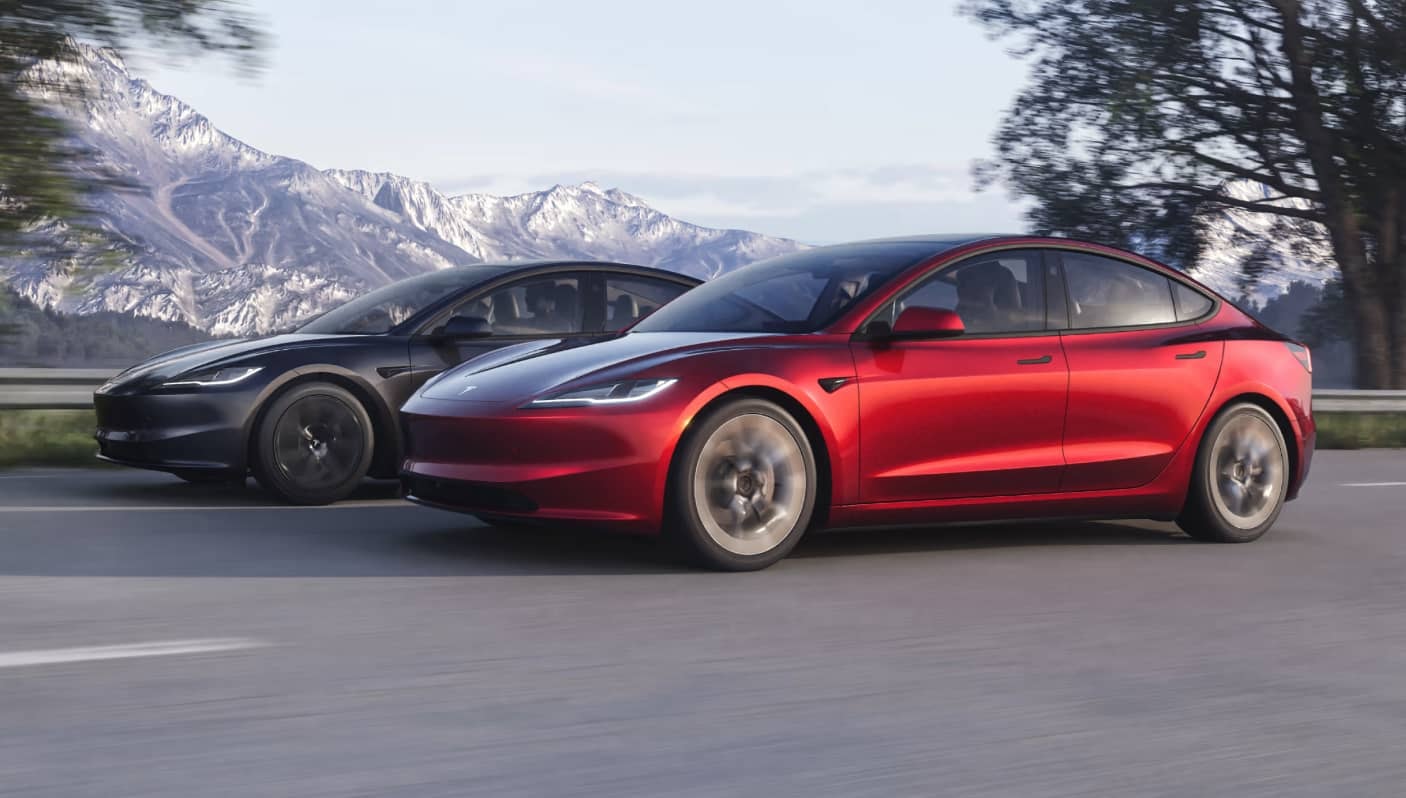 Tesla Model 3 en rojo circulando por carretera.